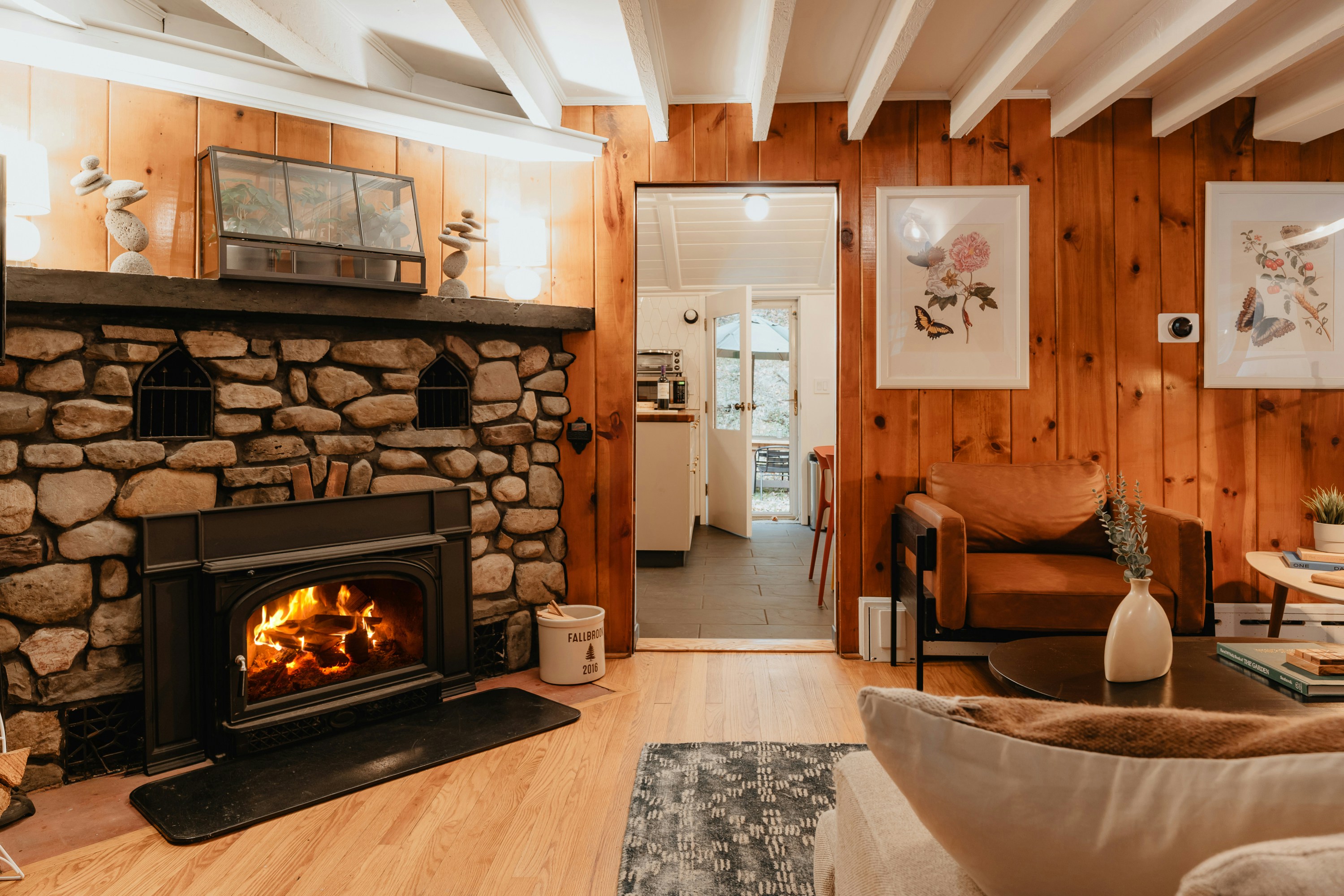A pine-paneled living room with a stone fireplace