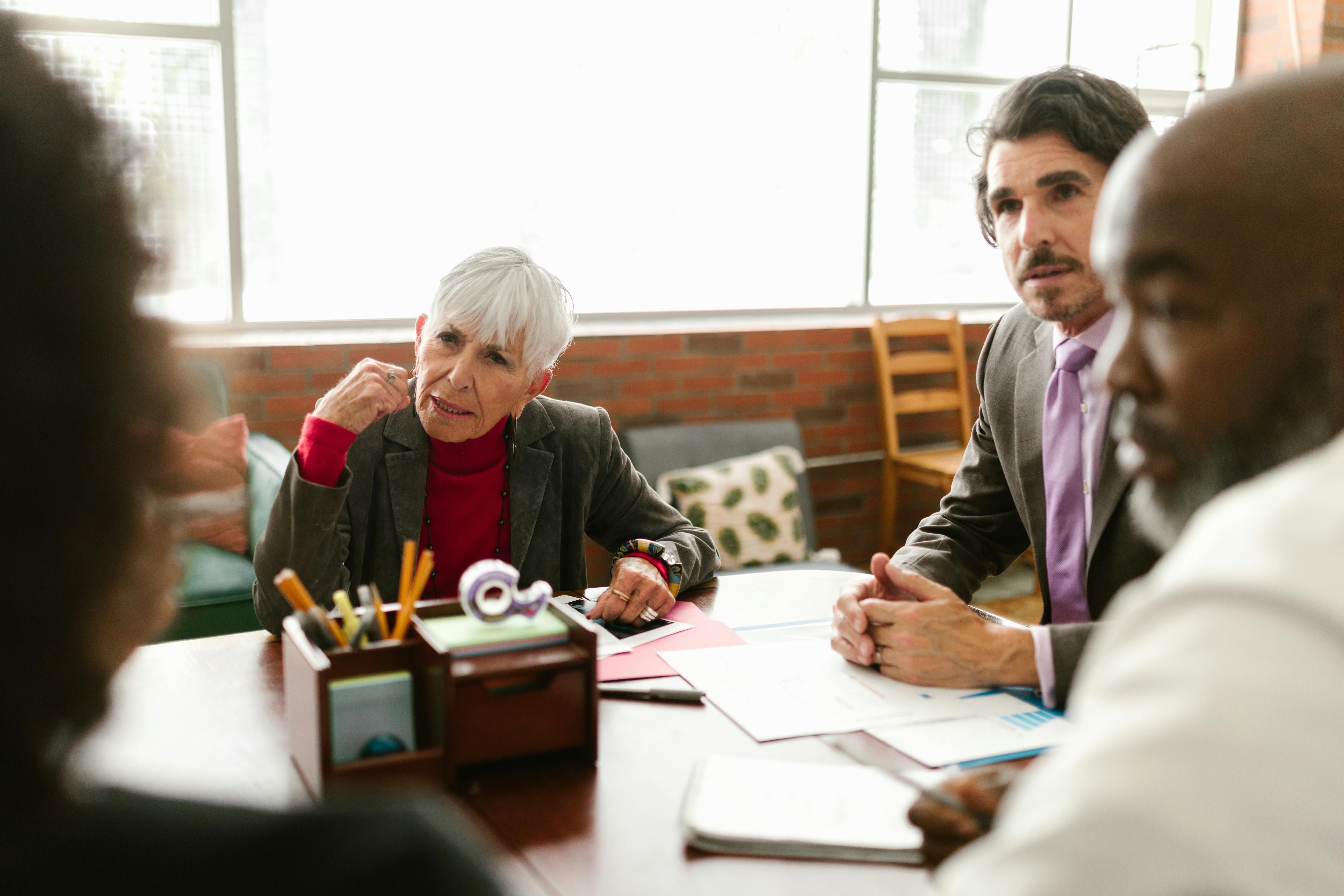 Diverse professional team discussing business strategy around an office table.