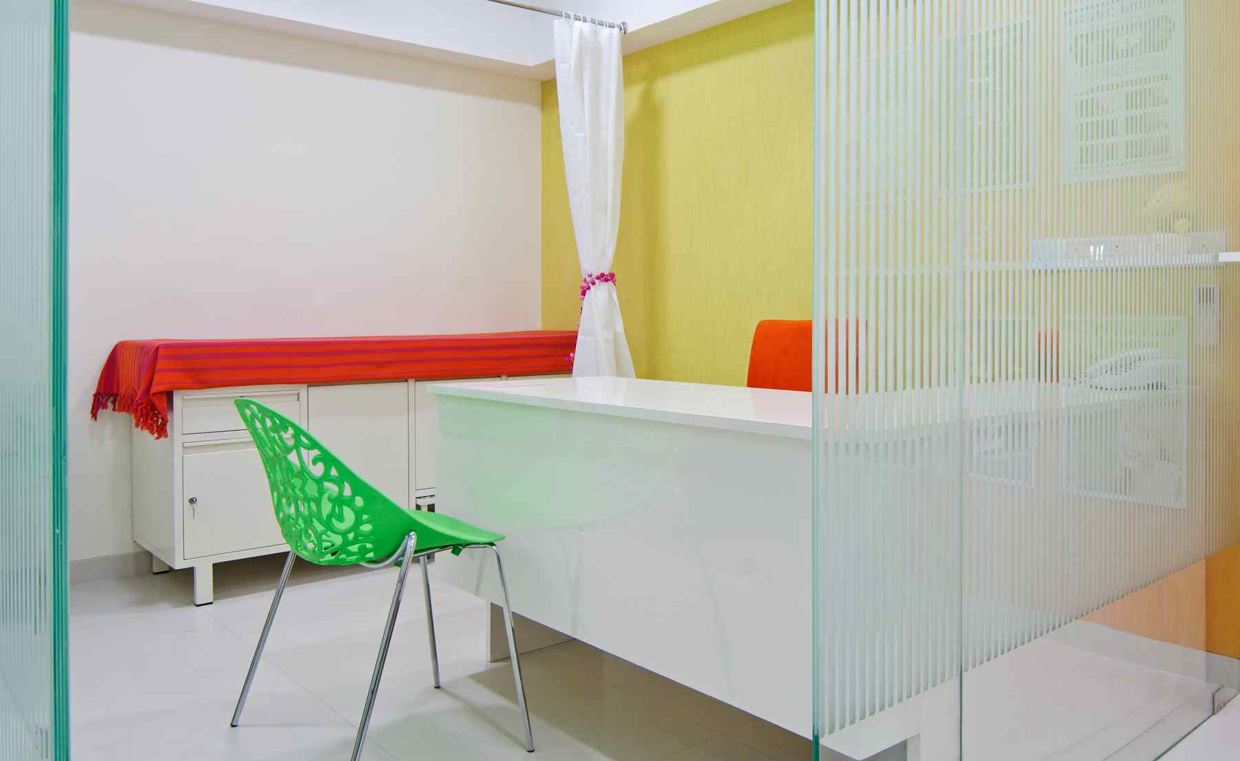 Nature-inspired preschool entrance with sculptural tree partitions and suspended green leaf ceiling panels.