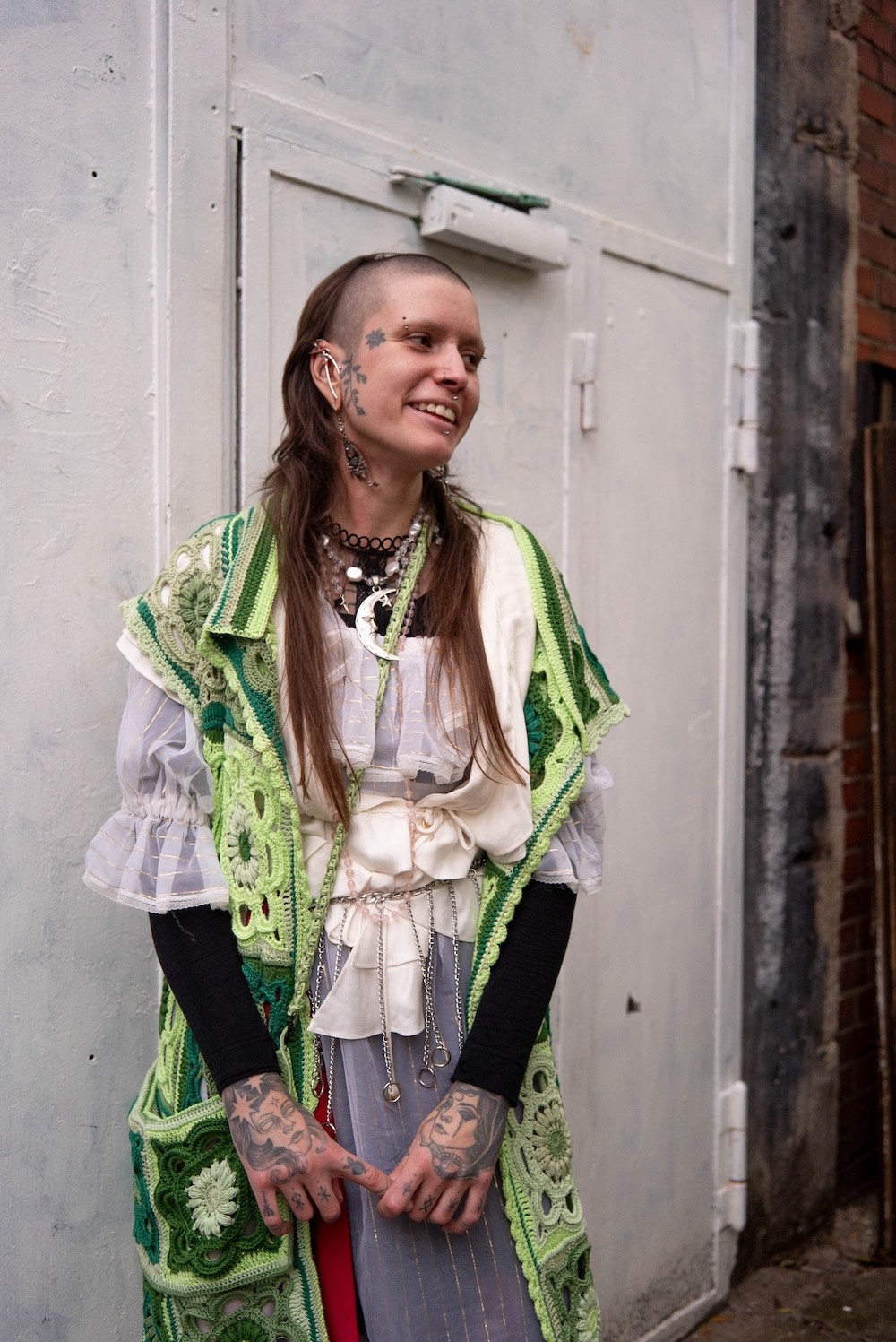 a woman standing in front of a brick building