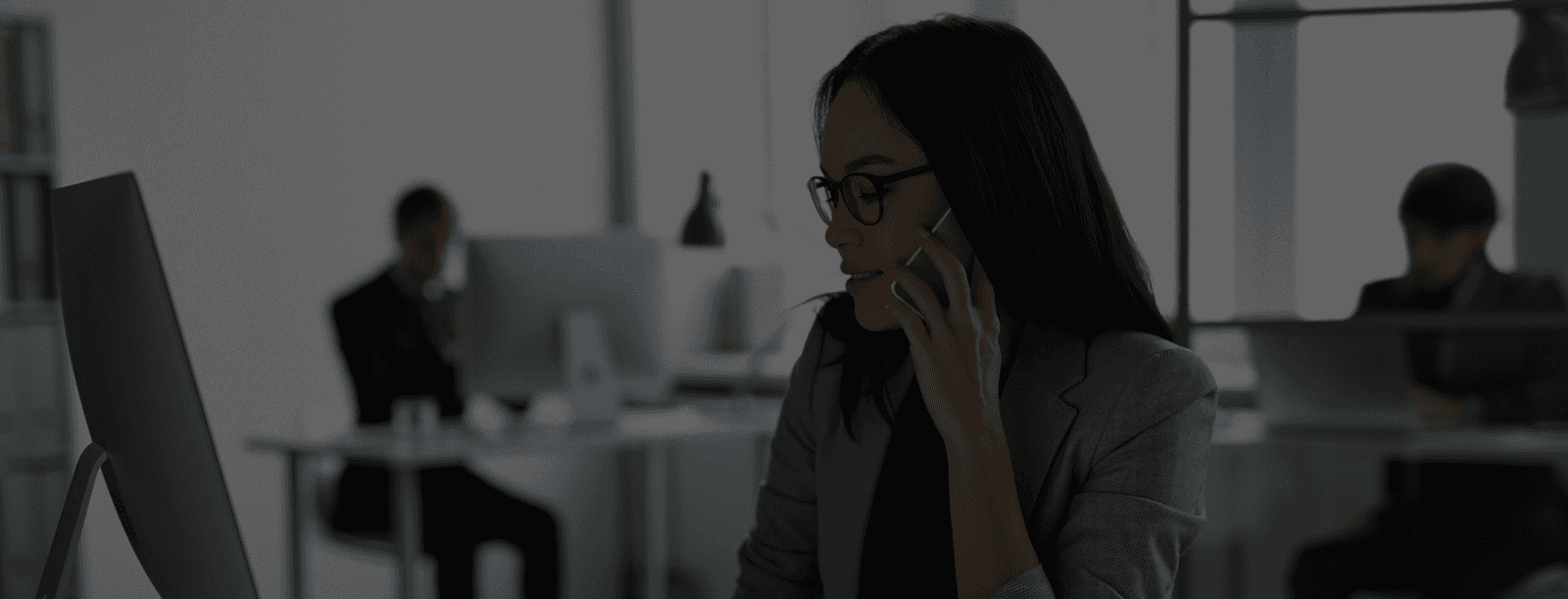 Aerial view of a city at sunset with buildings, bridges, and a river running through the center.