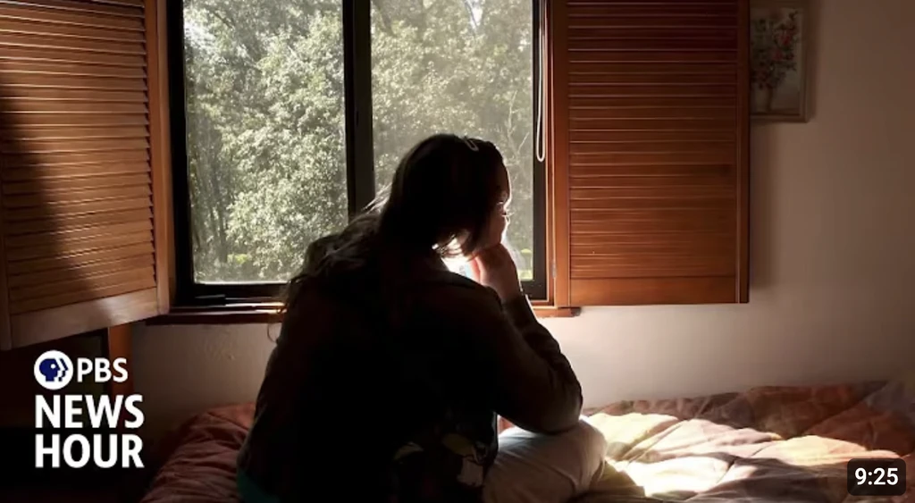 woman in black half-sleeved shirt sitting while facing woman and smiling