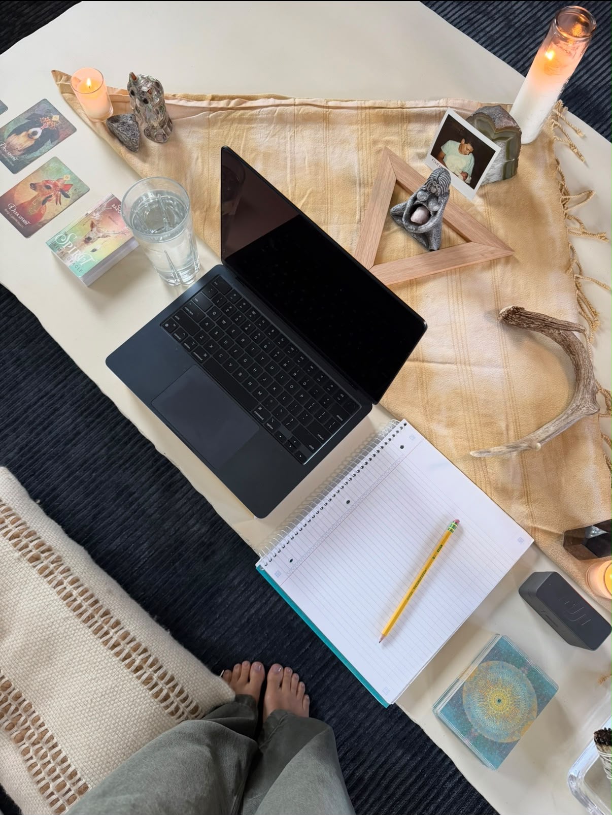 Overhead view of Christina’s reading space with laptop, notebook, cards, and candles