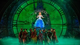 ロンドンのアポロ・ヴィクトリア劇場で上演中の『ウィキッド』。象徴的な大時計を背景に、シャボン玉に乗ってオズの市民に囲まれるグリンダ。