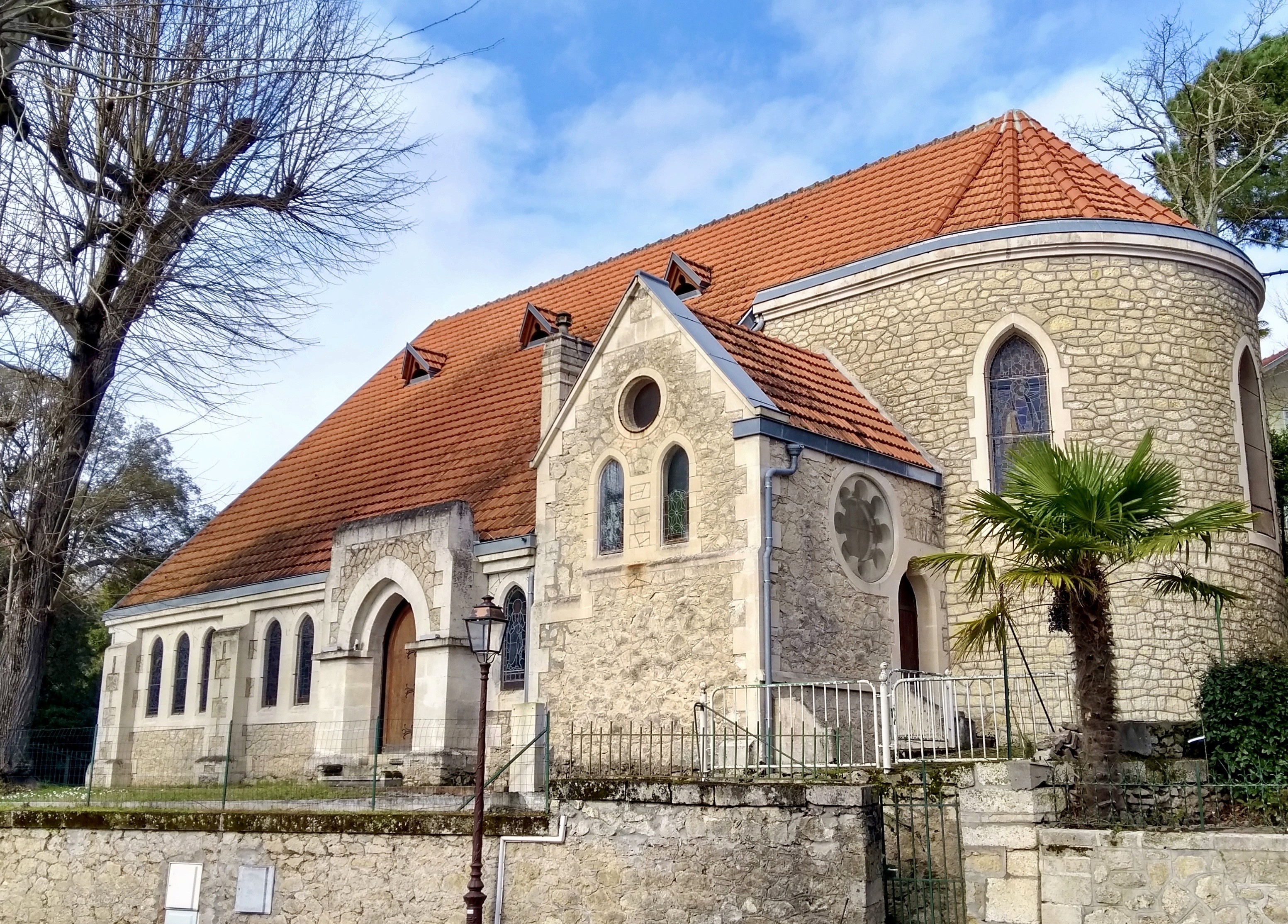A serene pathway lined with trees leads to a distant building, bathed in warm sunlight.
