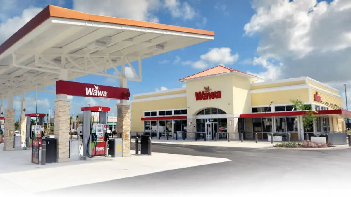Daytime view of a Wawa gas station and convenience store featuring fuel pumps under a large canopy and a bright, modern storefront with red signage. Captures the full-service Wawa experience including fuel and food offerings.