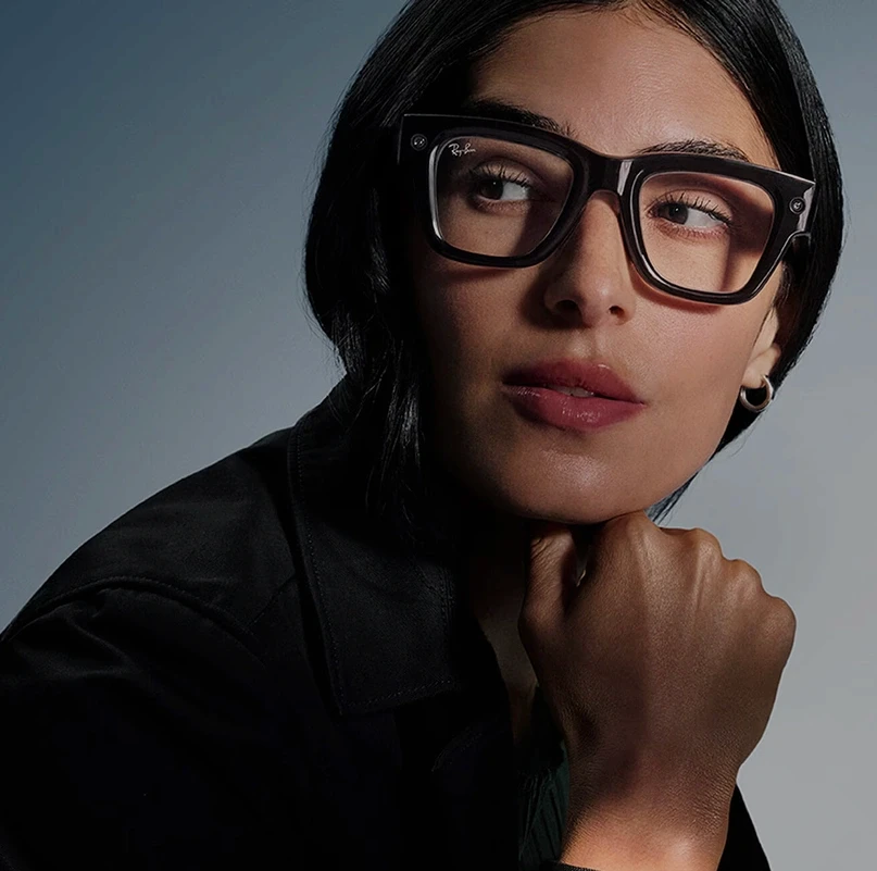 Person wearing Ray-Ban Meta smart glasses in a close-up portrait against a studio background