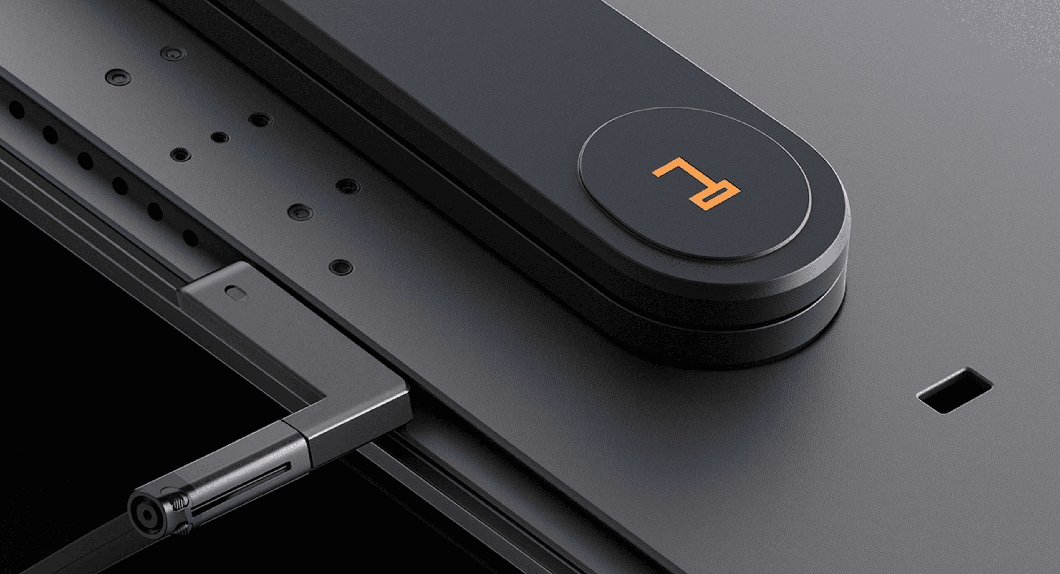 Close-up of a sleek black electronic device with orange logo detail