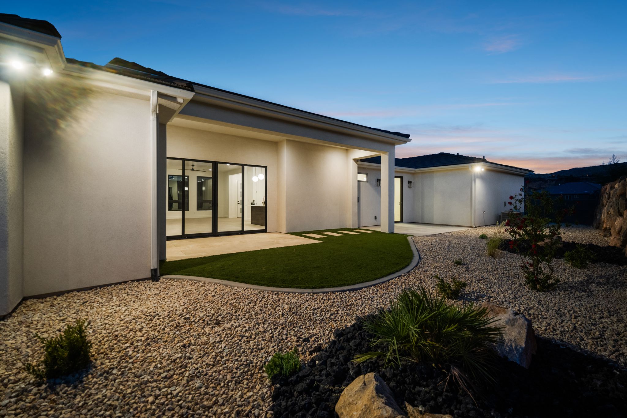 Backyard of The Overlook at Falcon Ridge in Hurricane, Utah, featuring a concrete patio, landscaped yard.