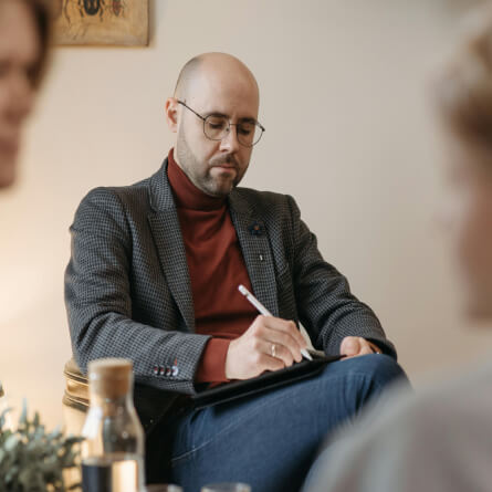 A therapist writing down on his notebook
