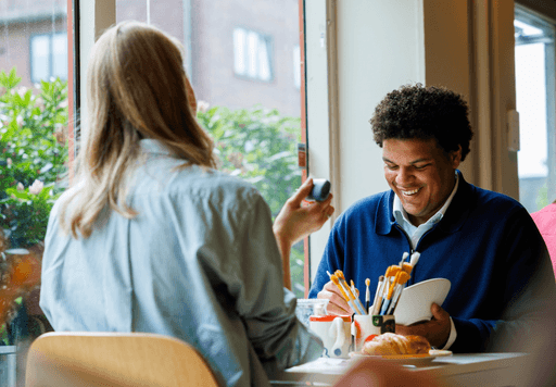 Mennesker som sitter ved et bord og maler på keramikk