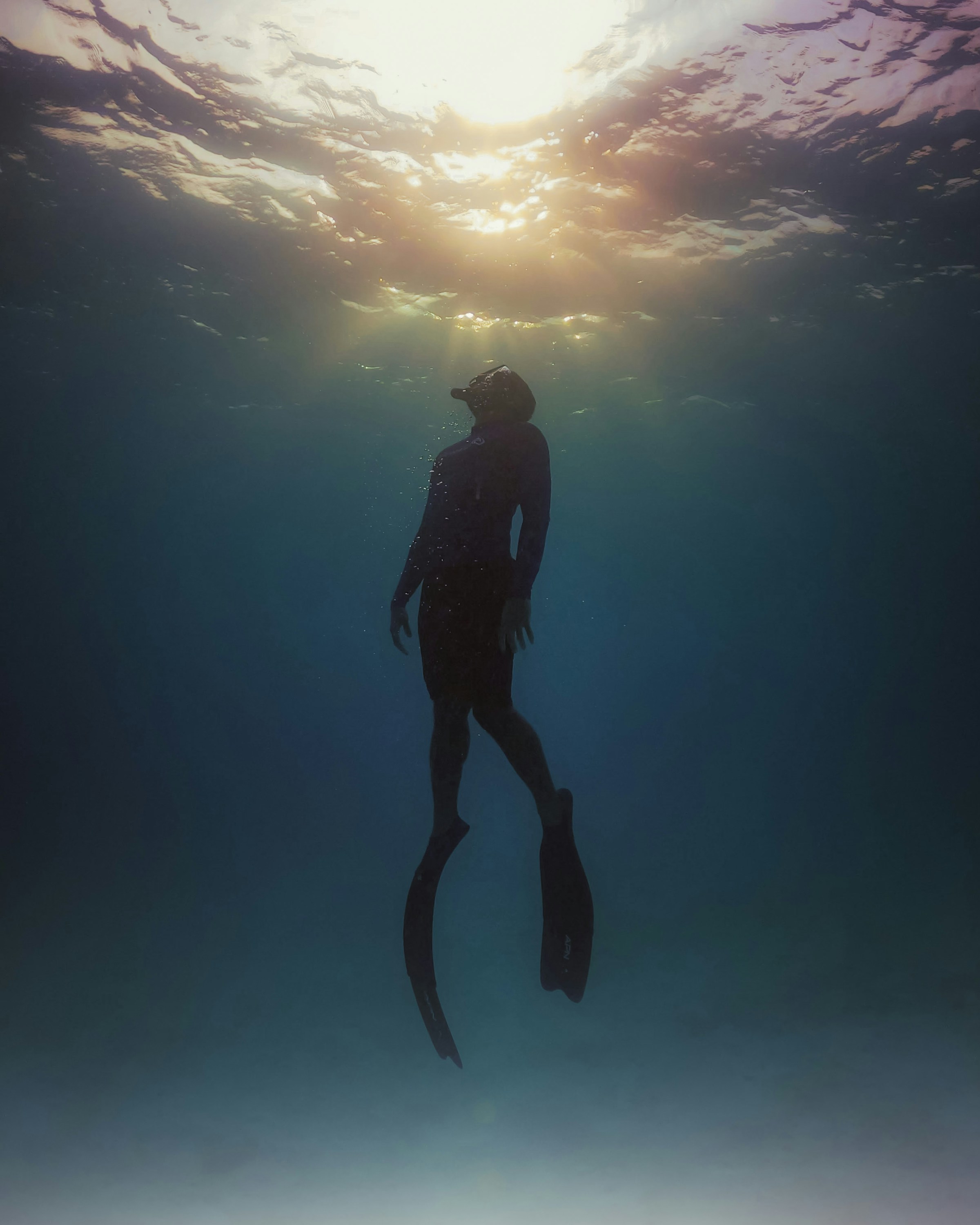 A diver looking up at sunlight through the surface
