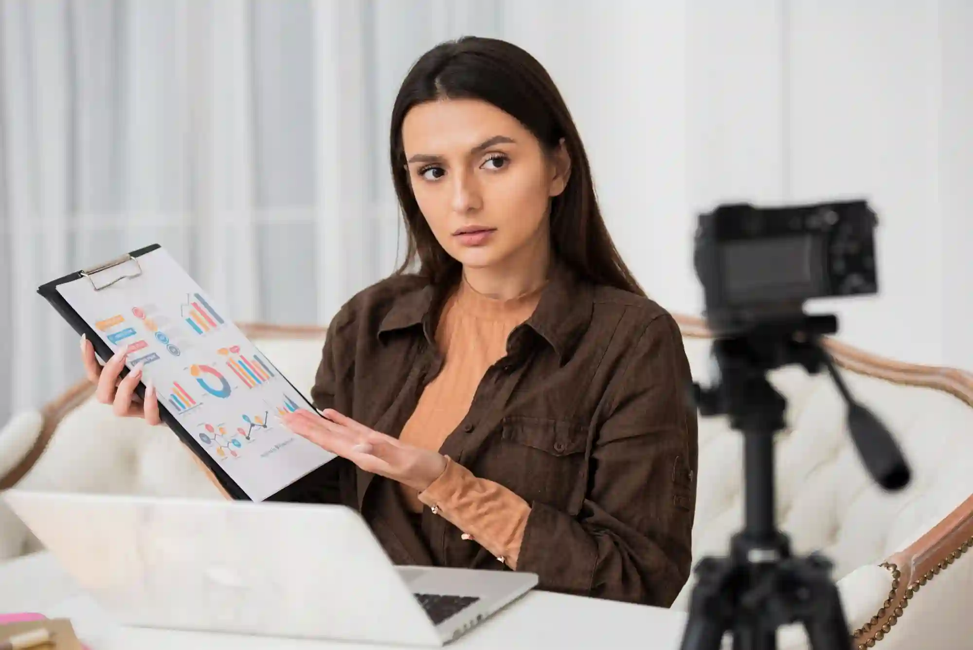 A woman presents data charts to a camera, illustrating expert financial analysis and educational video content creation.