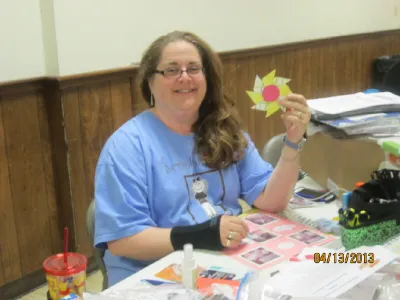 Woman holding up a pinwheel paper craft at a crop