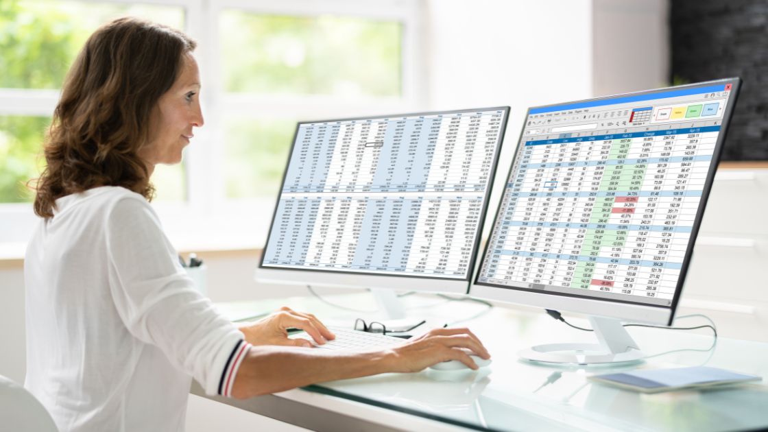 Woman working on dual monitor computer
