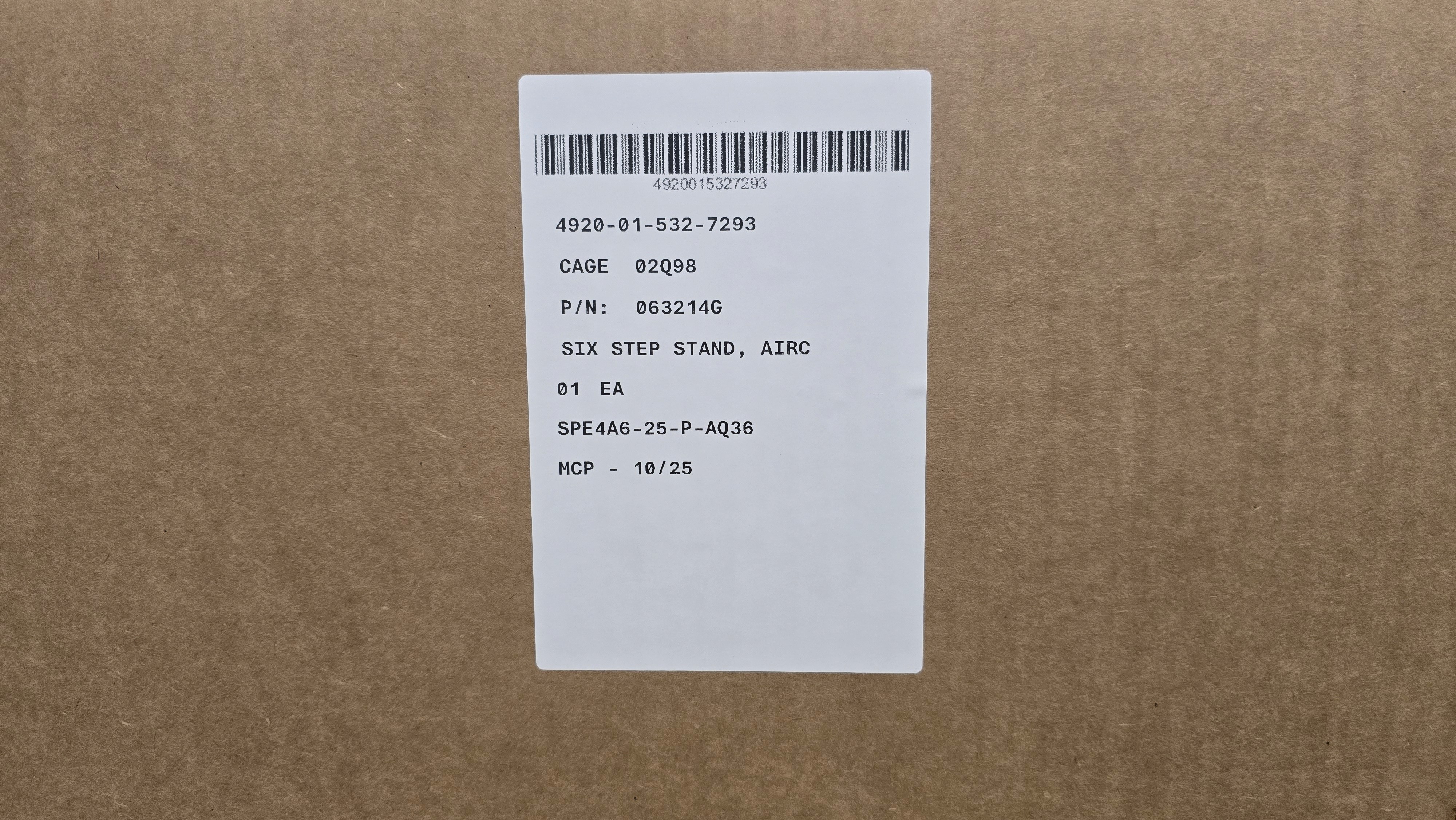 Close-up of a dark green leaf showing its textured surface and central vein against a muted background.