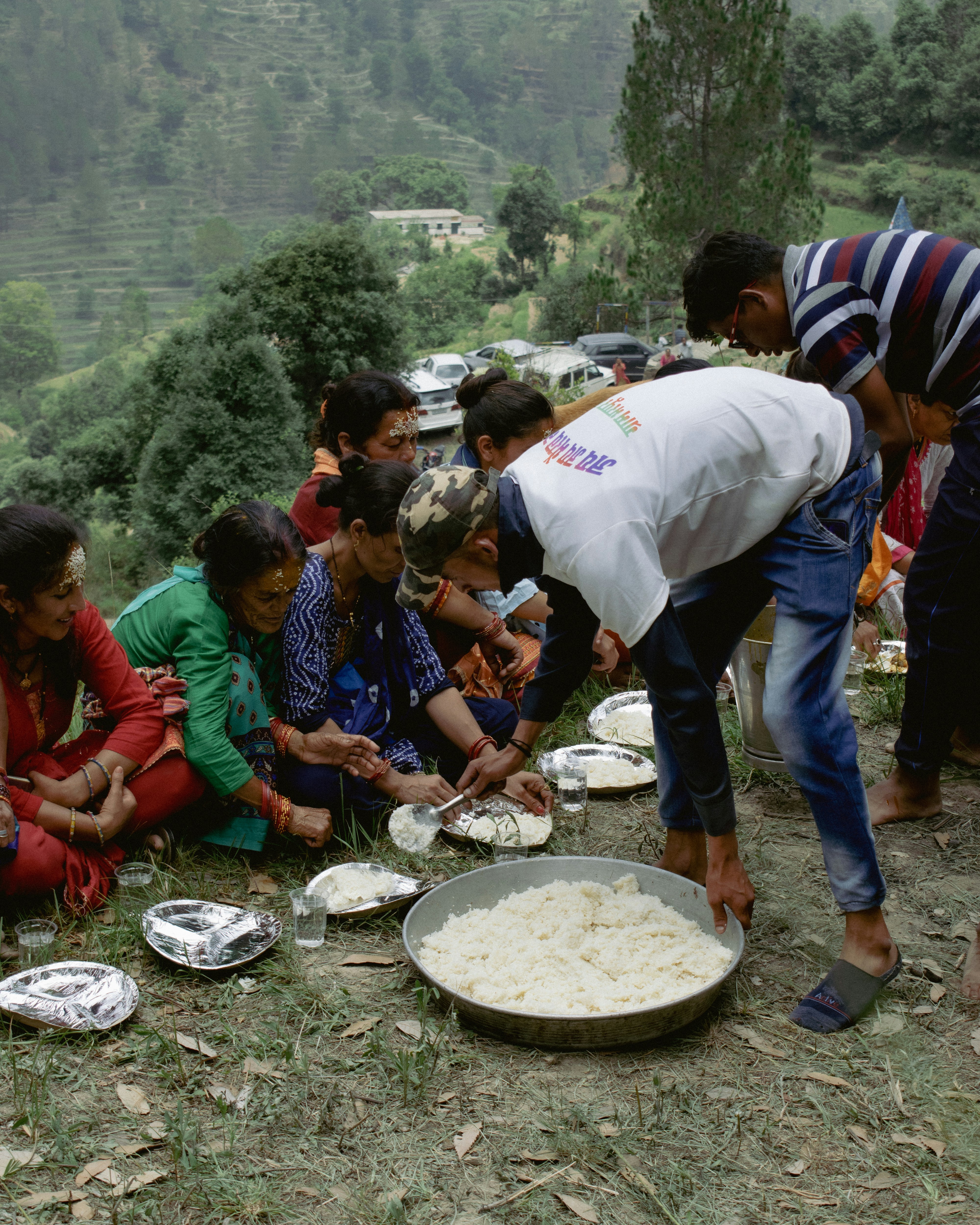a group of people sitting on the ground with food on plates