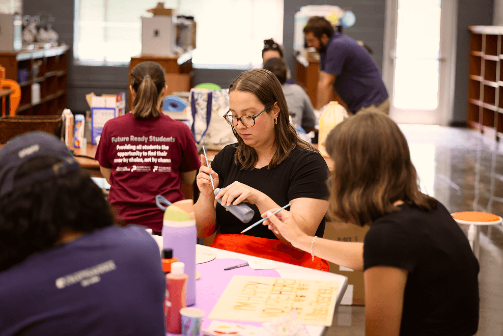 Residents from PEF's teacher residency creating signs for their classrooms featuring tools from VW eLabs.