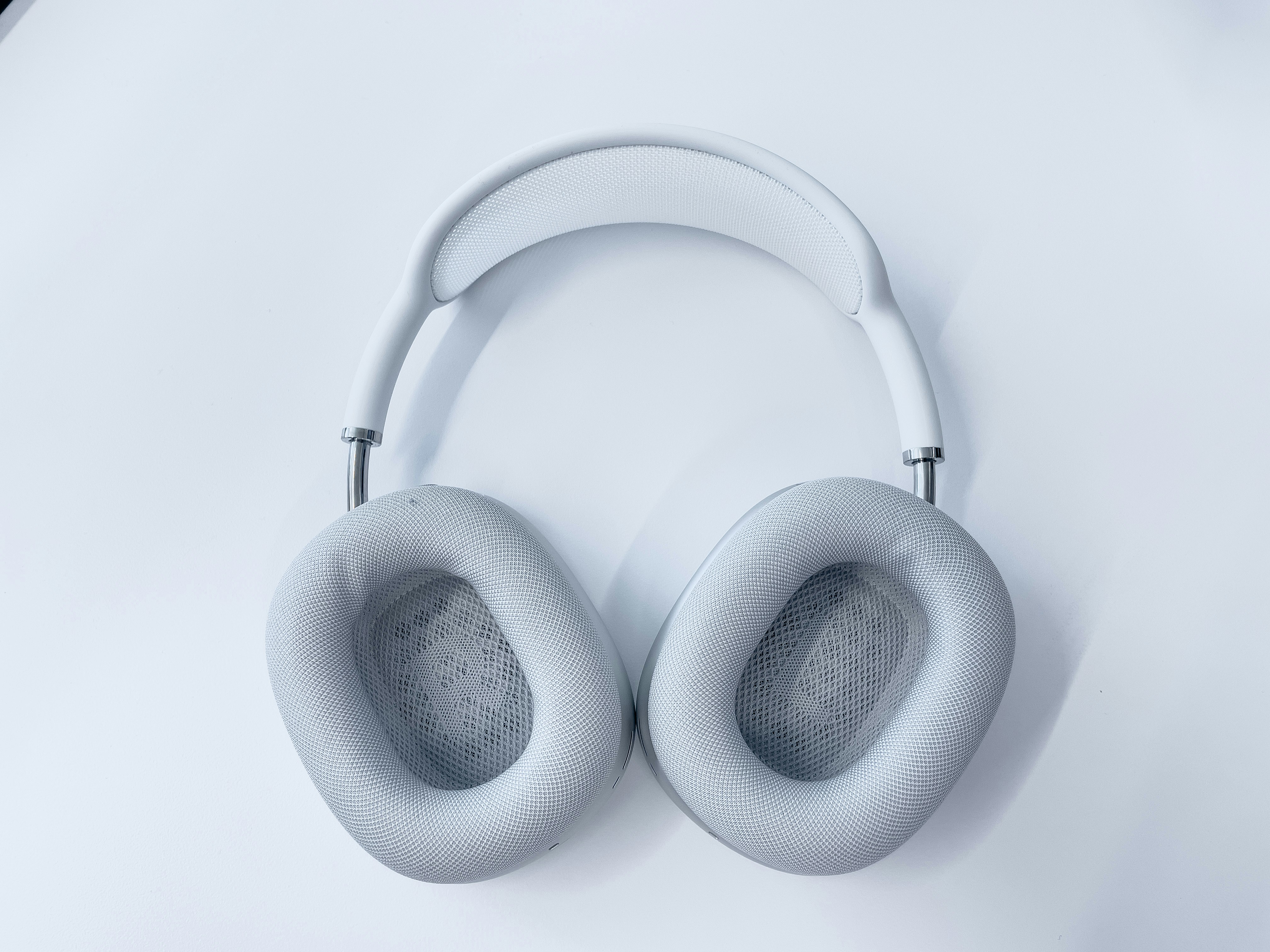 white wireless headphones on white surface