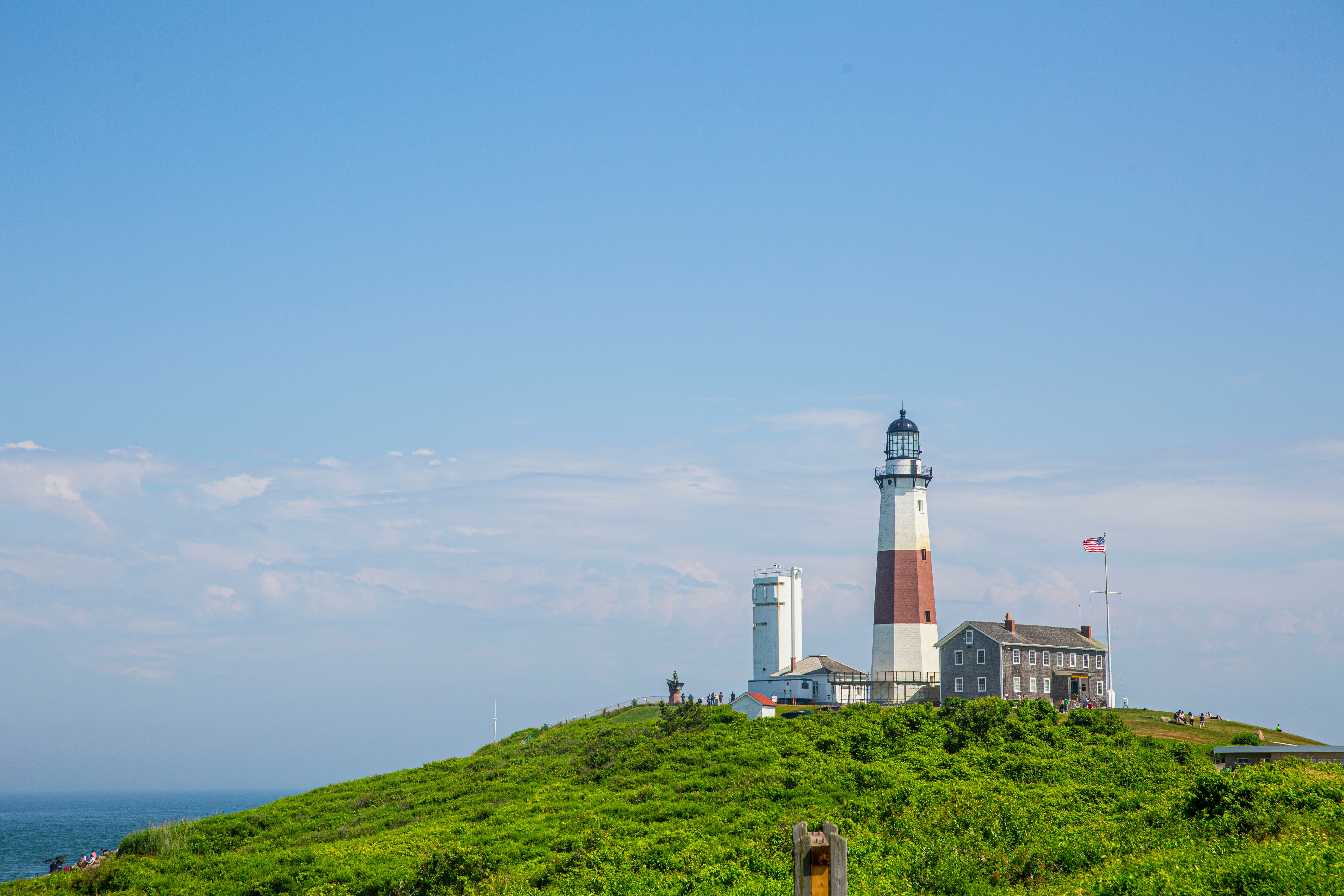 a lighthouse on top of a grassy hill