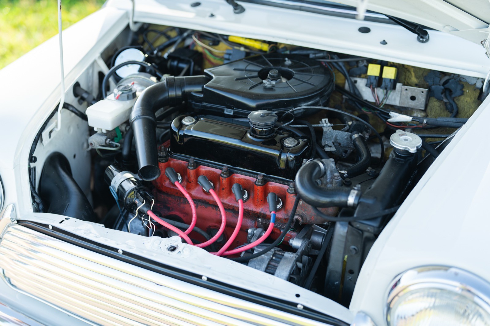 Close-up of a car engine, showcasing components like wires, hoses, and the engine block under the hood.