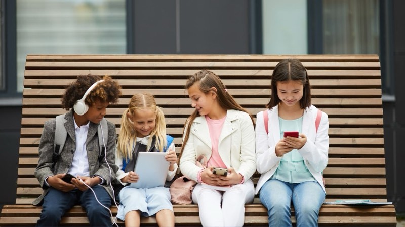 children interacting with screens and devices instead of socializing