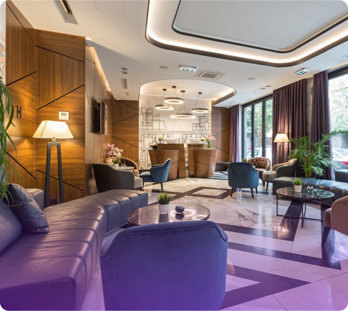 Modern lounge area with purple carpet, elegant seating, and stylish lighting, creating a cozy atmosphere.