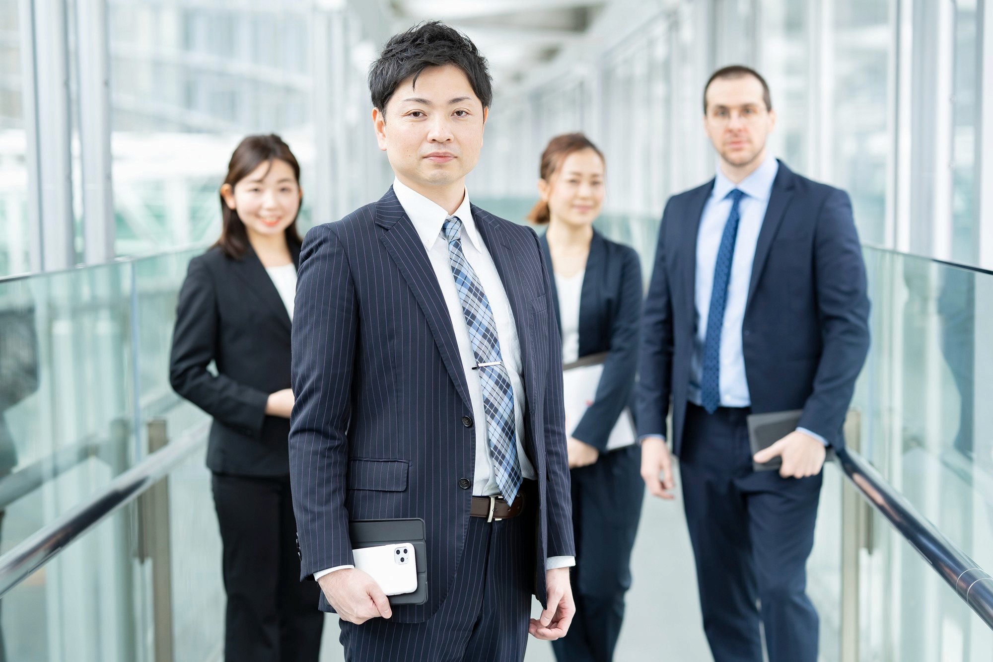 穿著深色西裝的專業顧問團隊於現代辦公室環境，提供香港工程保險及勞工保險等企業方案諮詢。