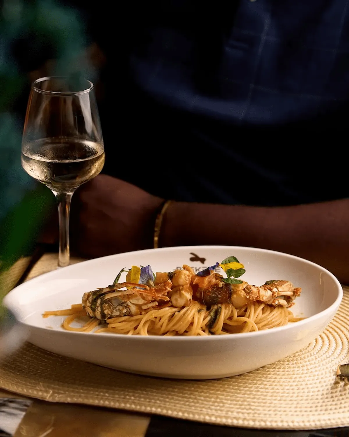 A gourmet seafood pasta dish paired with white wine.