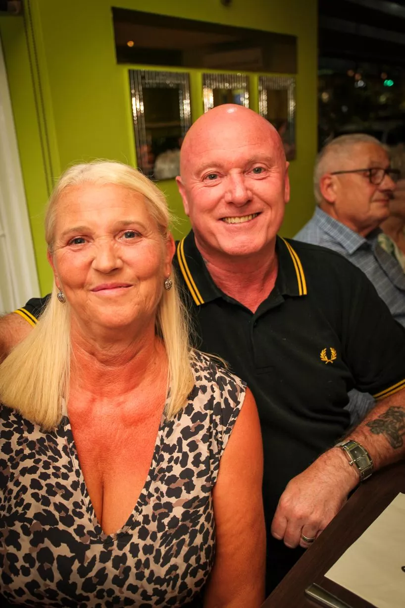 A man and woman sat smiling at the camera