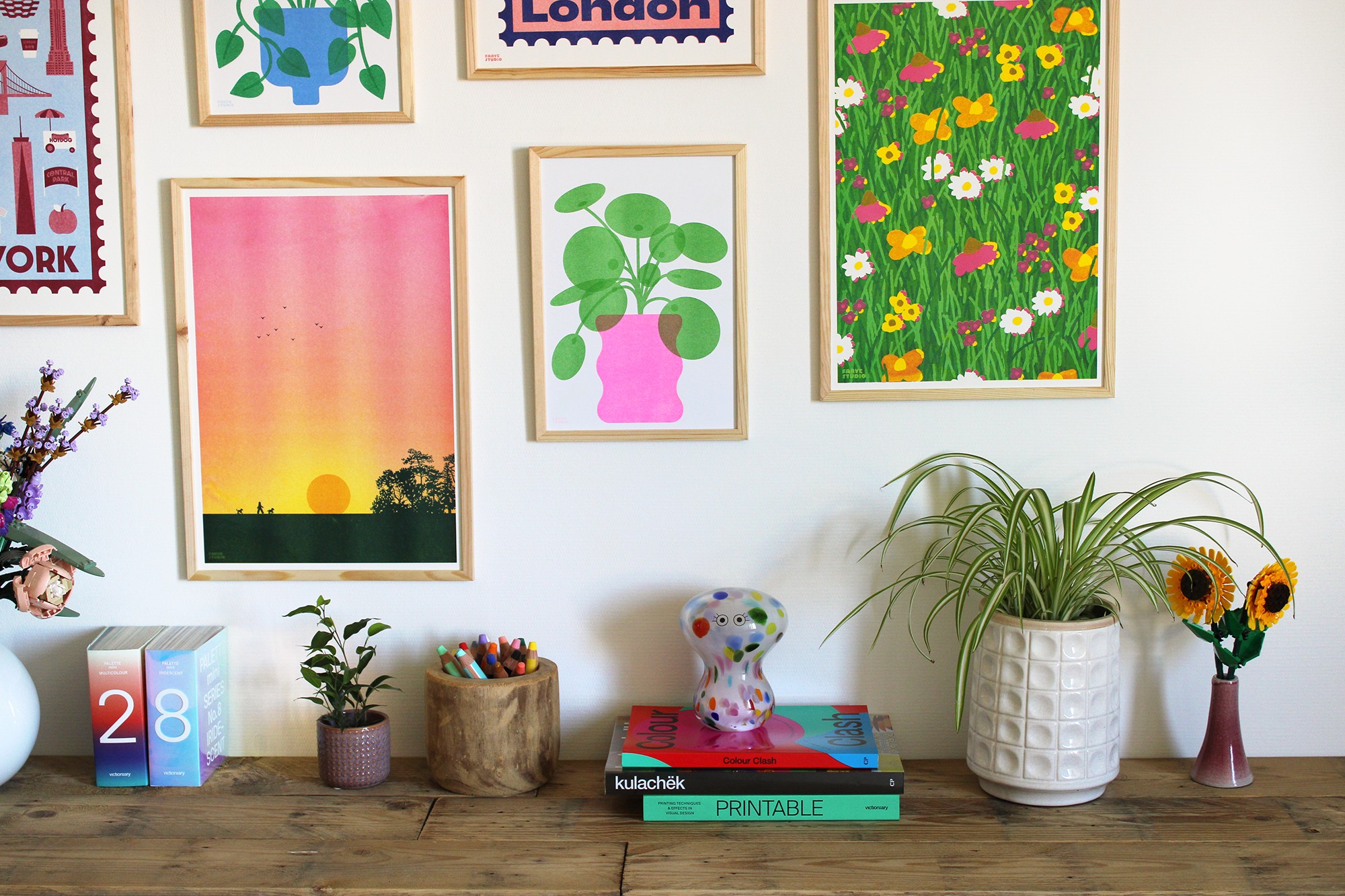 Mur de cadres avec décorations sur meuble devant