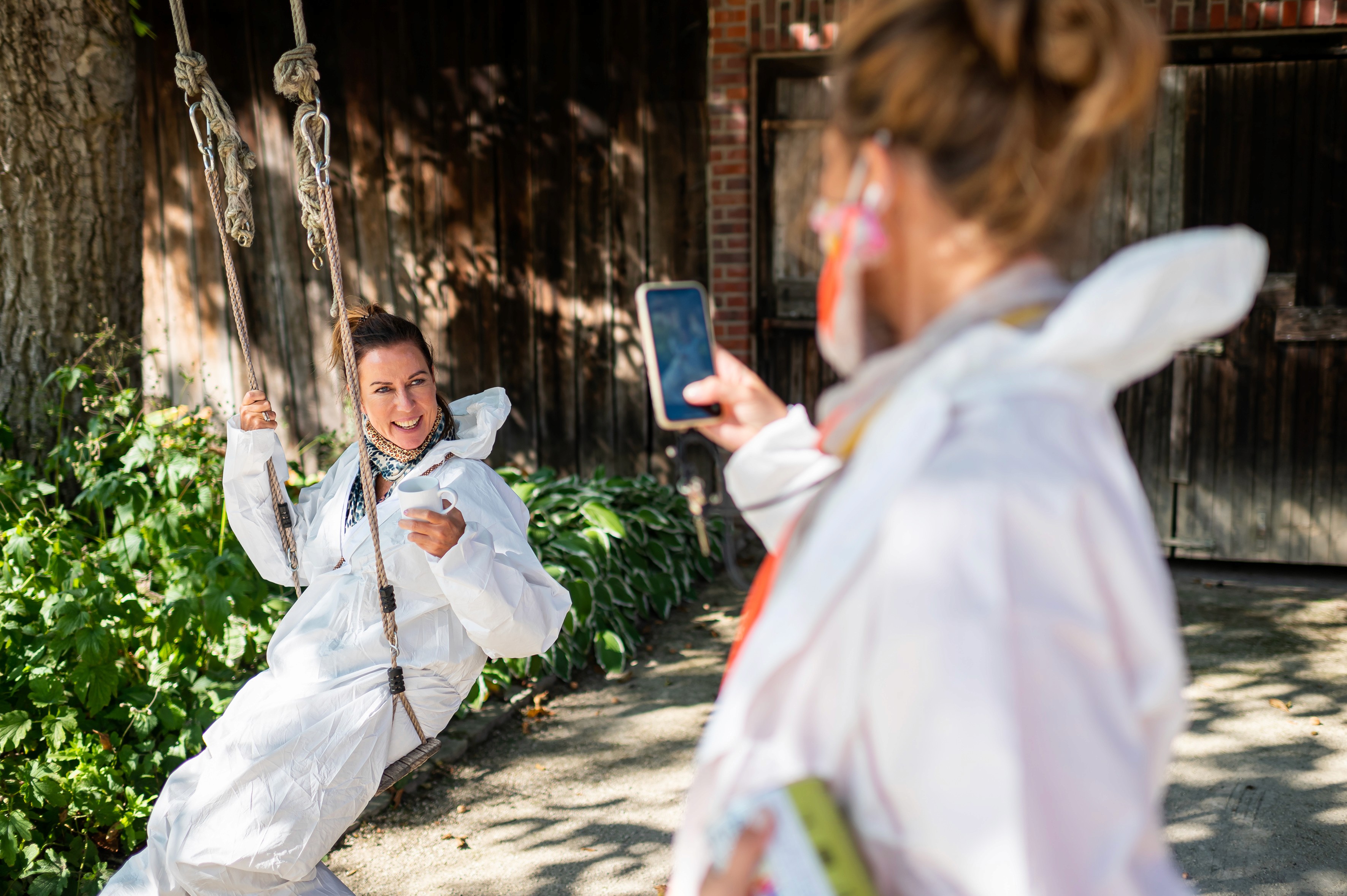 Zwei Creator fotografieren sich beim Garden & Home Blog Award in Schutzanzügen auf einer Schaukel.