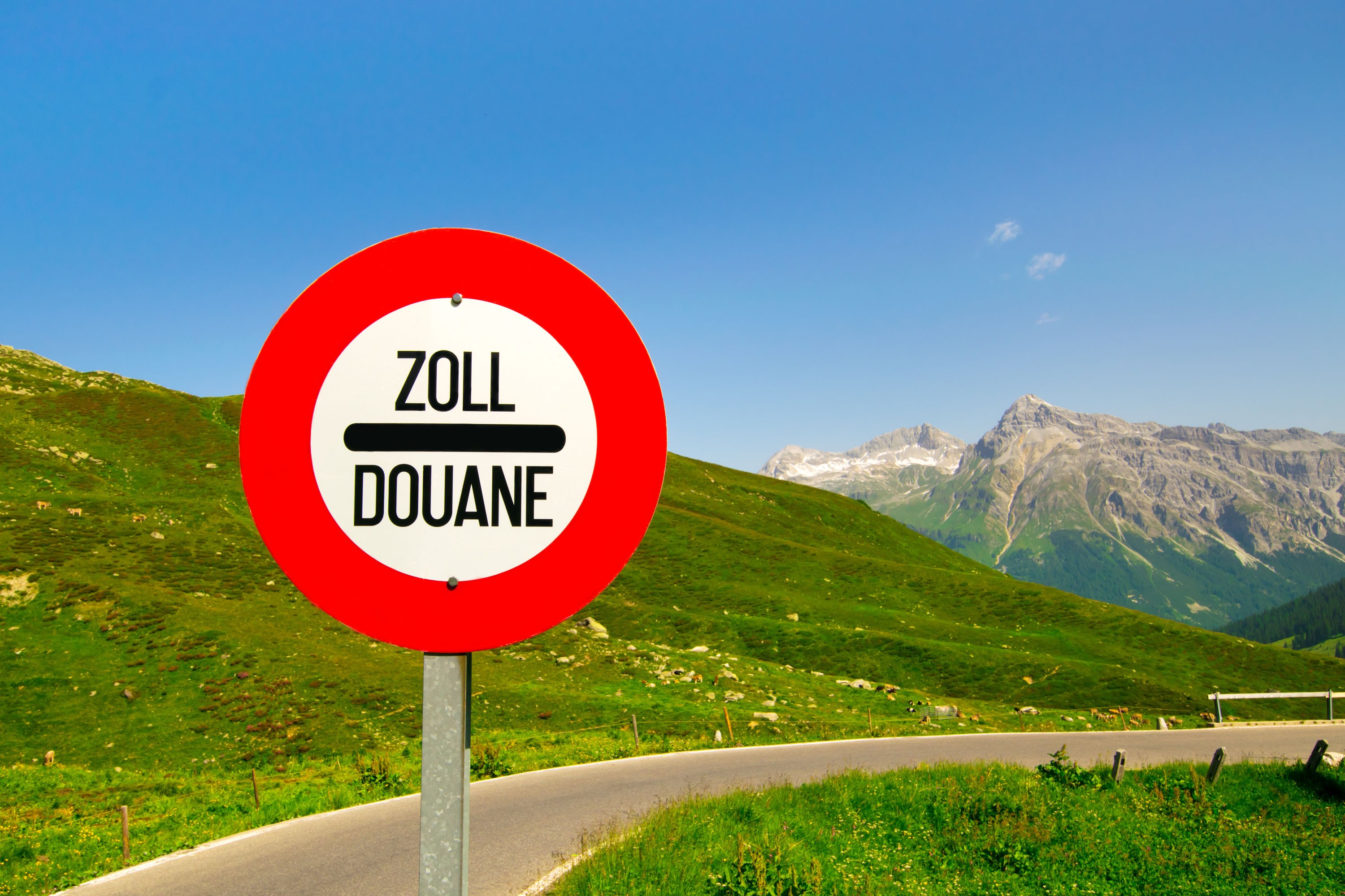 Customs sign beside a mountain road in the Swiss Alps.