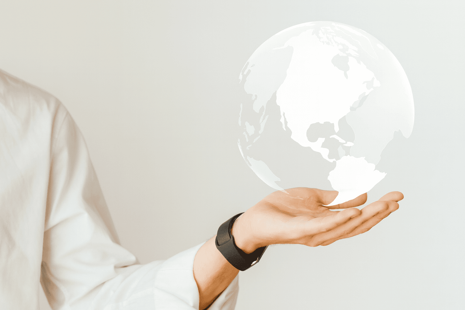Une main tenant une illustration lumineuse d'un globe terrestre, symbolisant la portée mondiale et la visibilité offerte aux vendeurs sur Amazon.
