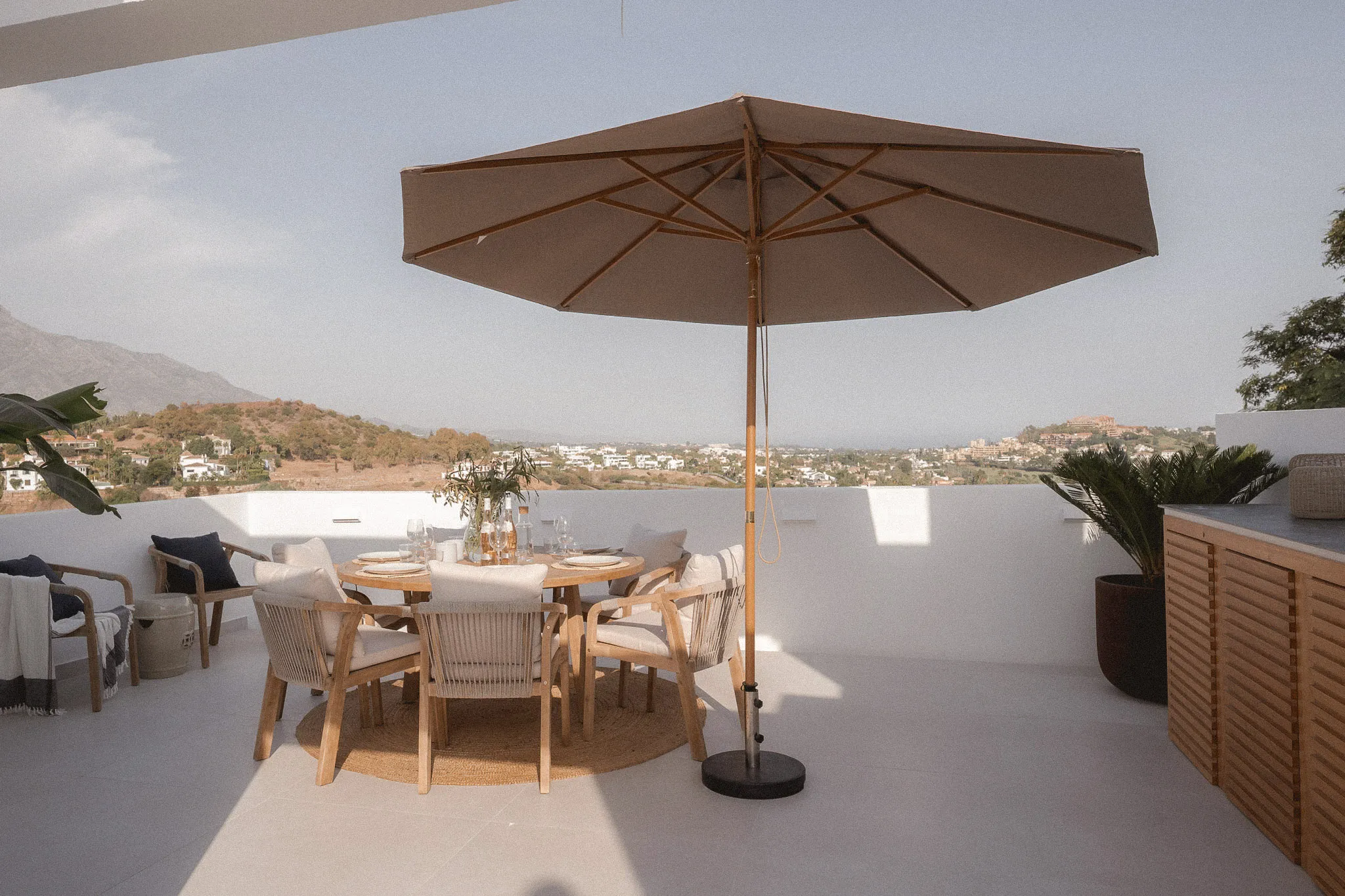 Outdoor dining terrace at La Quinta Townhouse in Marbella with mountain views