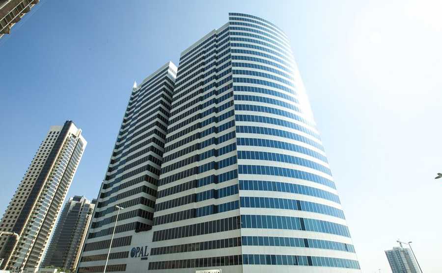 Low-angle view of Opal Tower under a clear sky, highlighting available commercial units for lease and sale.