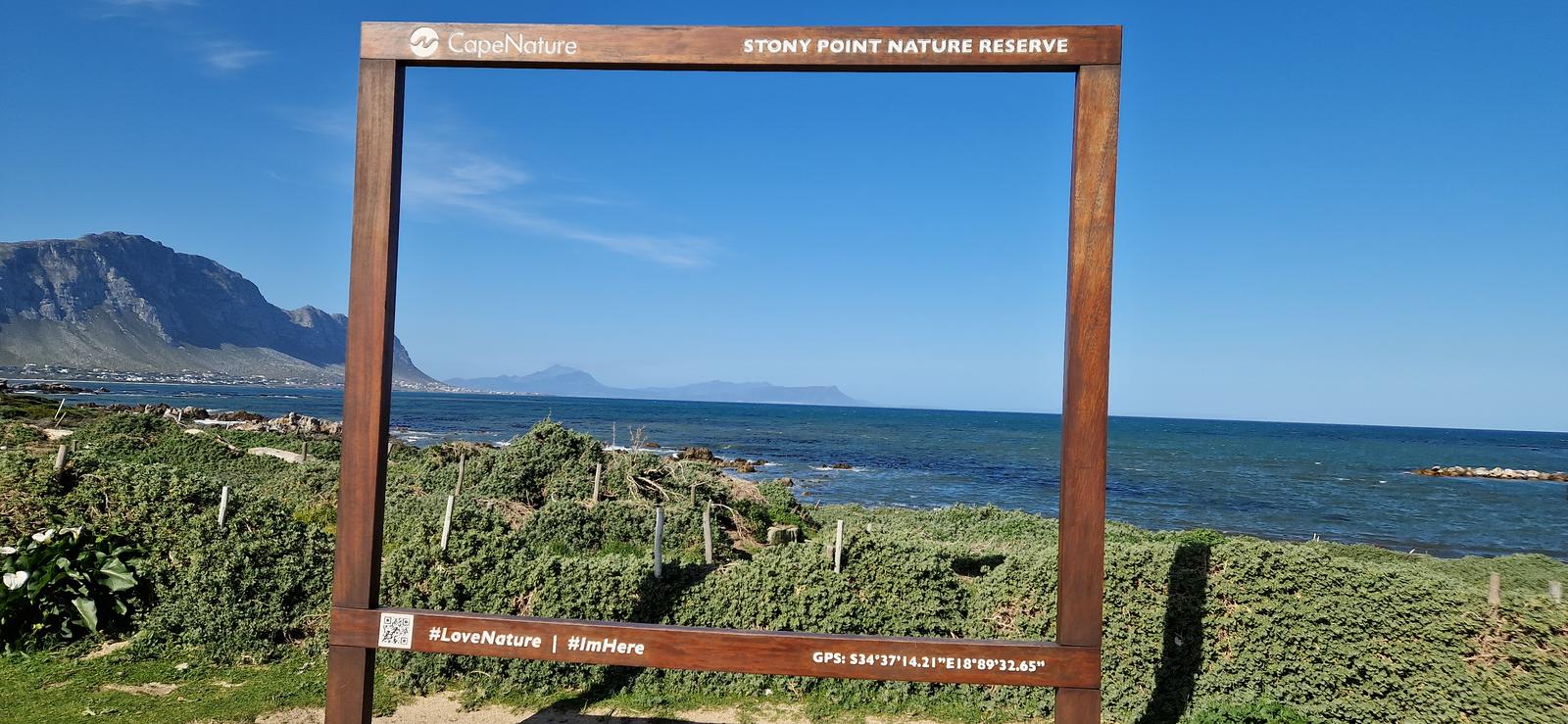Giant photo frame at Stony Point Nature Reserve for tourists, with the mountains and ocean visible in the background on a beautiful day.