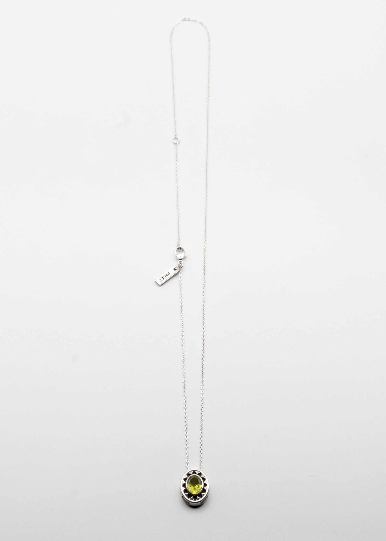 Silver necklace with a green peridot pendant on a white background