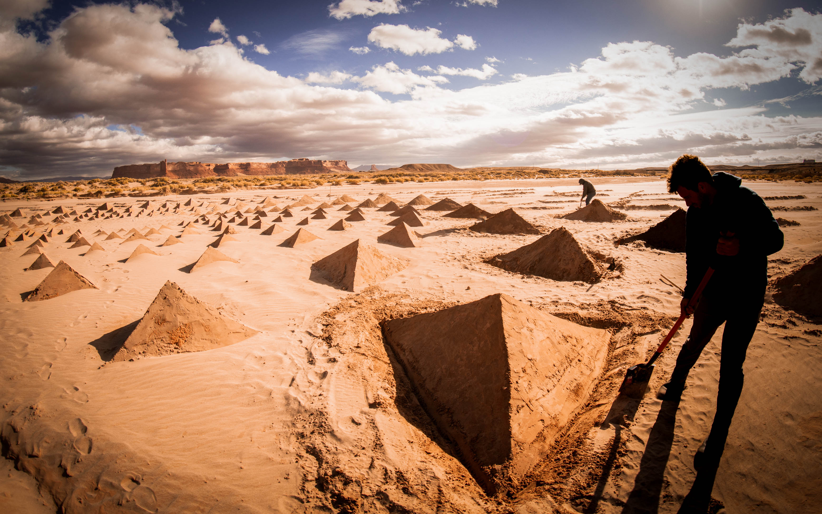 Land artist Brighton Denevan shoveling sand while constructing the land art for Owen Brown’s ARIZONA music video