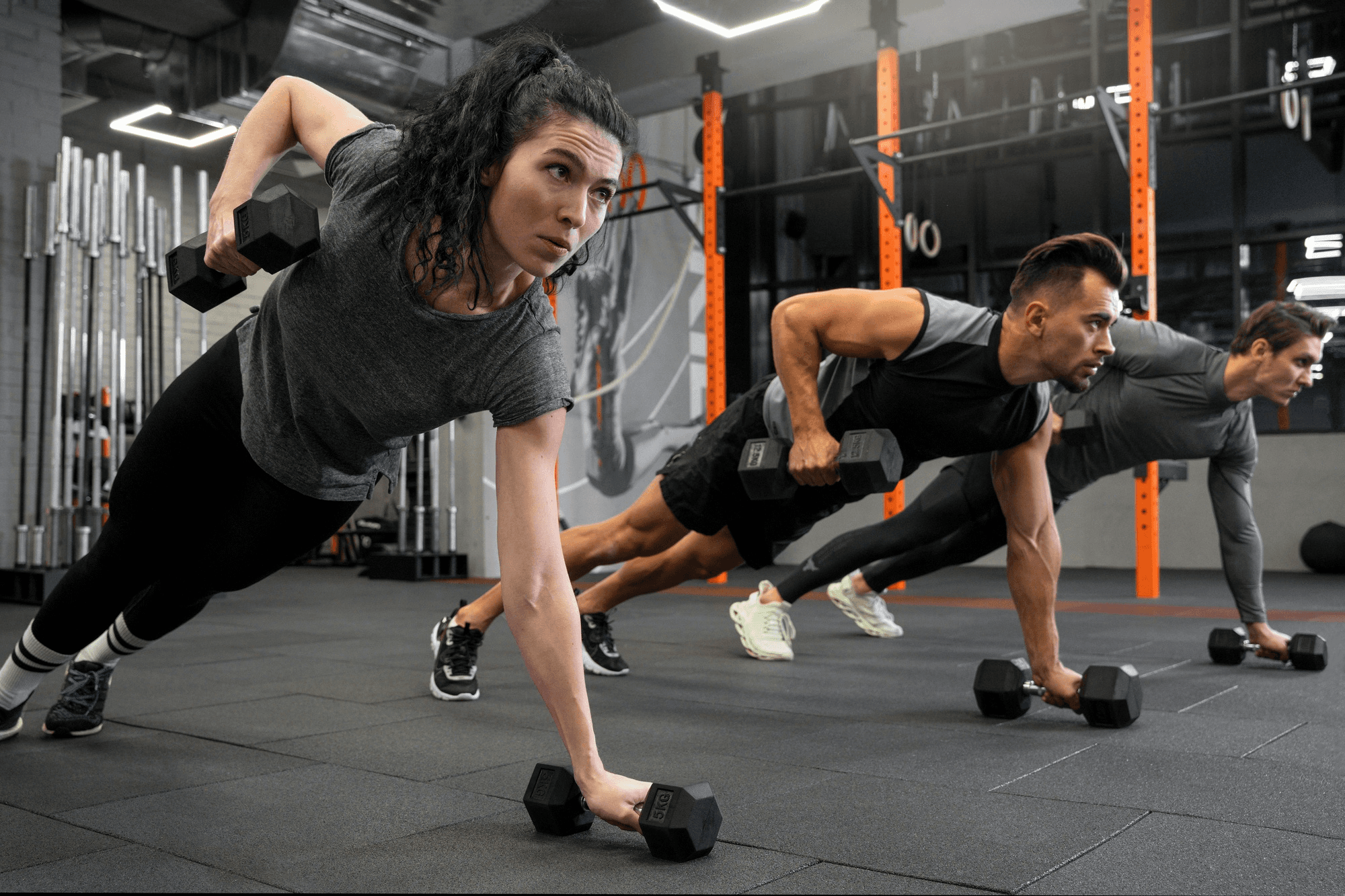 People working out indoors together using dumbbells, an example of cross training.