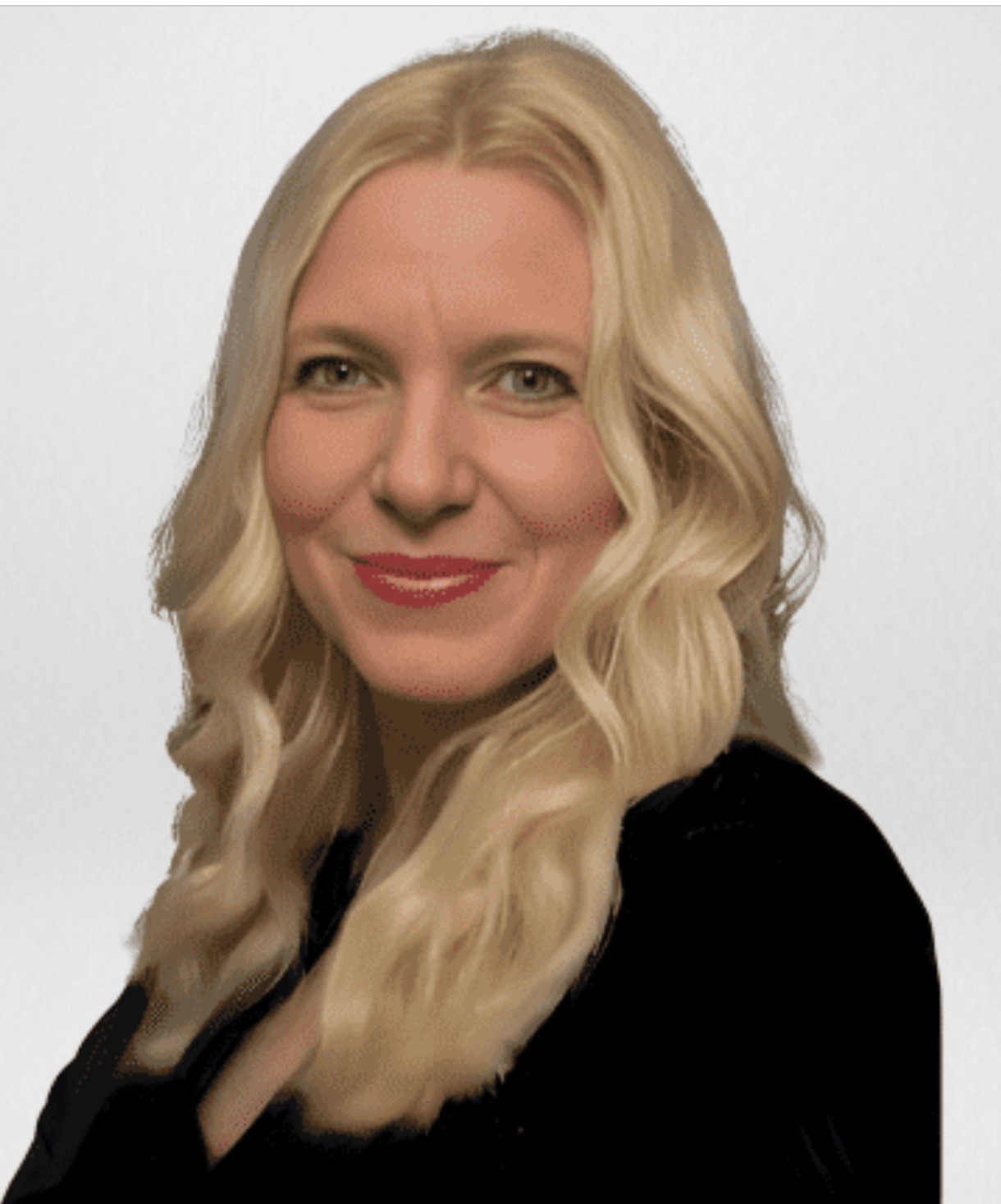 Smiling woman in beige linen outfit standing indoors with plants and books in the background.