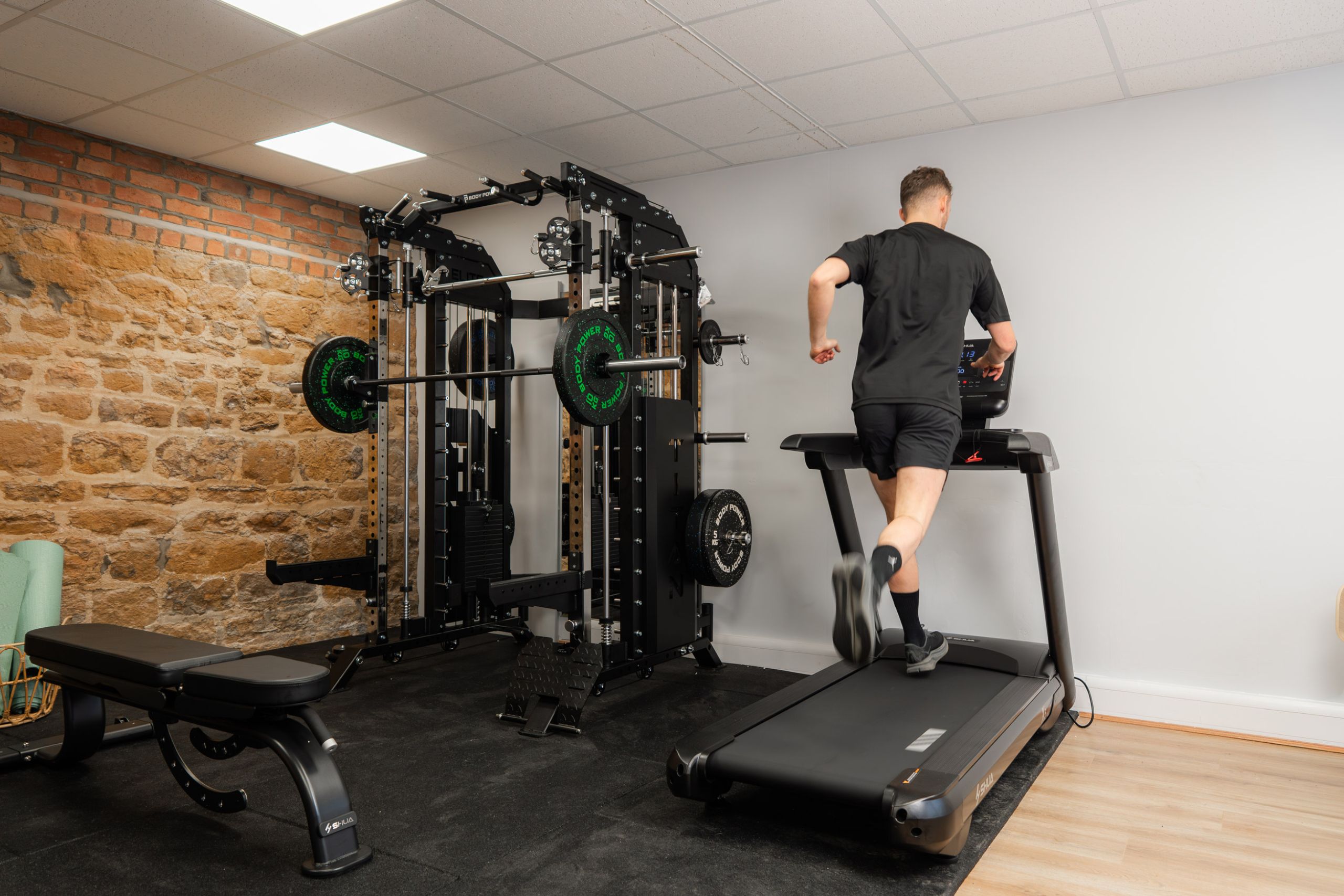 Man running on treadmill in personal training fitness suite