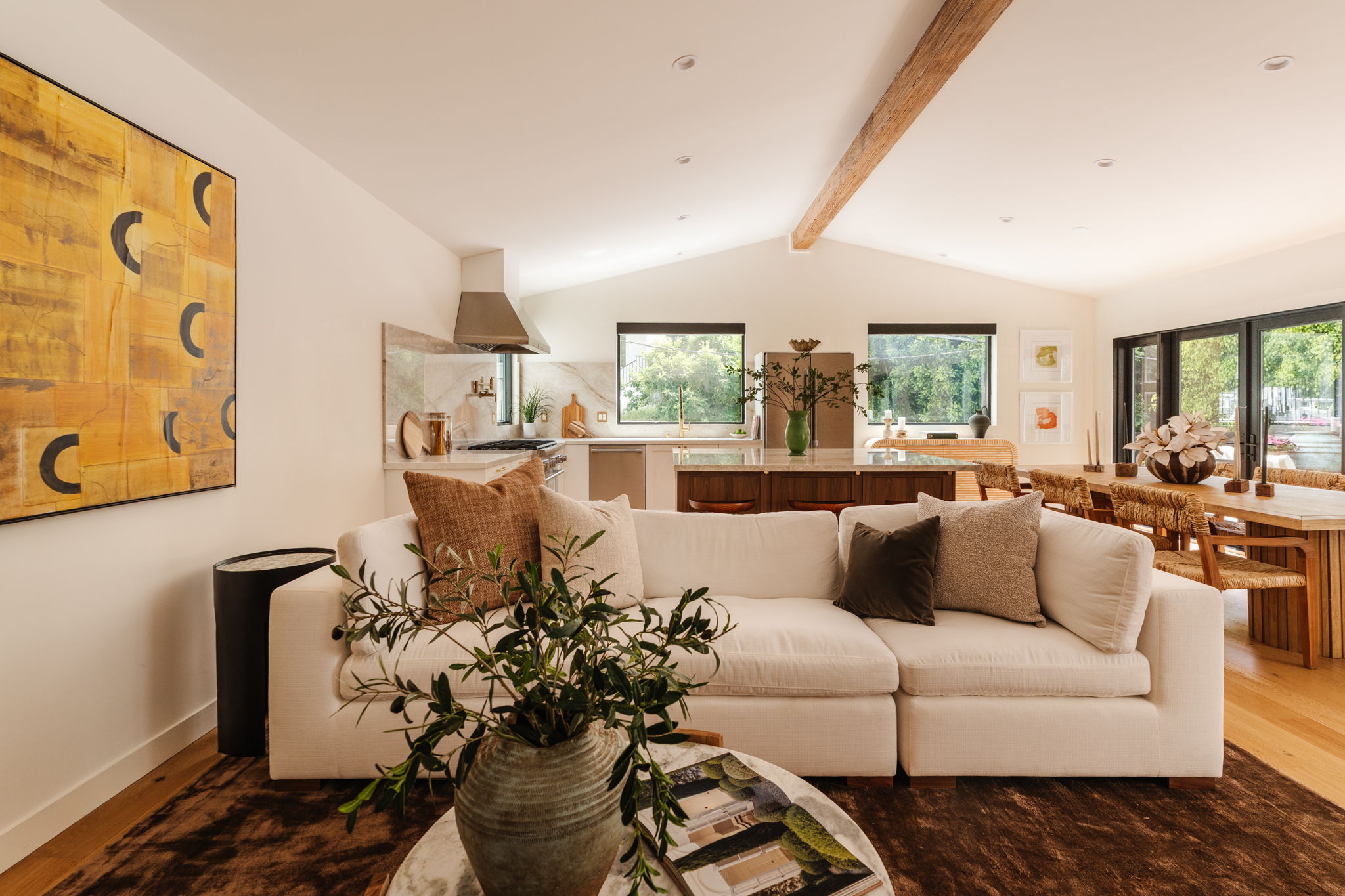 Modern living room with black leather sofas and tree-patterned rug
