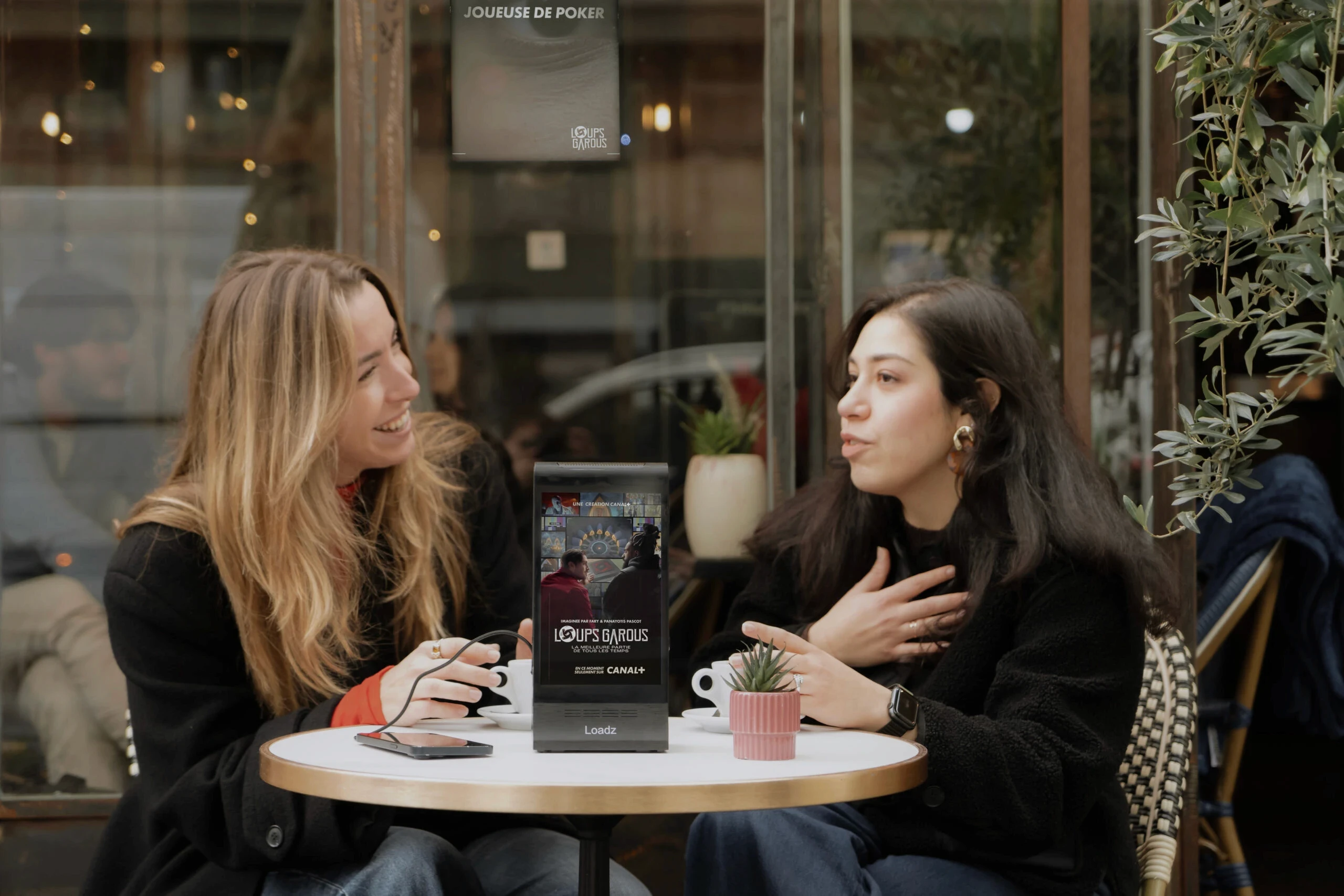 A person in business attire lies amidst scattered papers and folders on a red carpet, holding a phone receiver. The scene conveys chaos and stress.