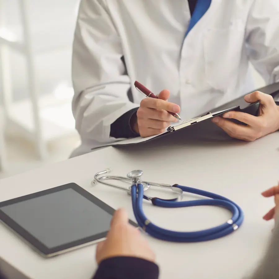 AI tools for medical professionals capturing notes as a doctor writes on a clipboard with a stethoscope nearby