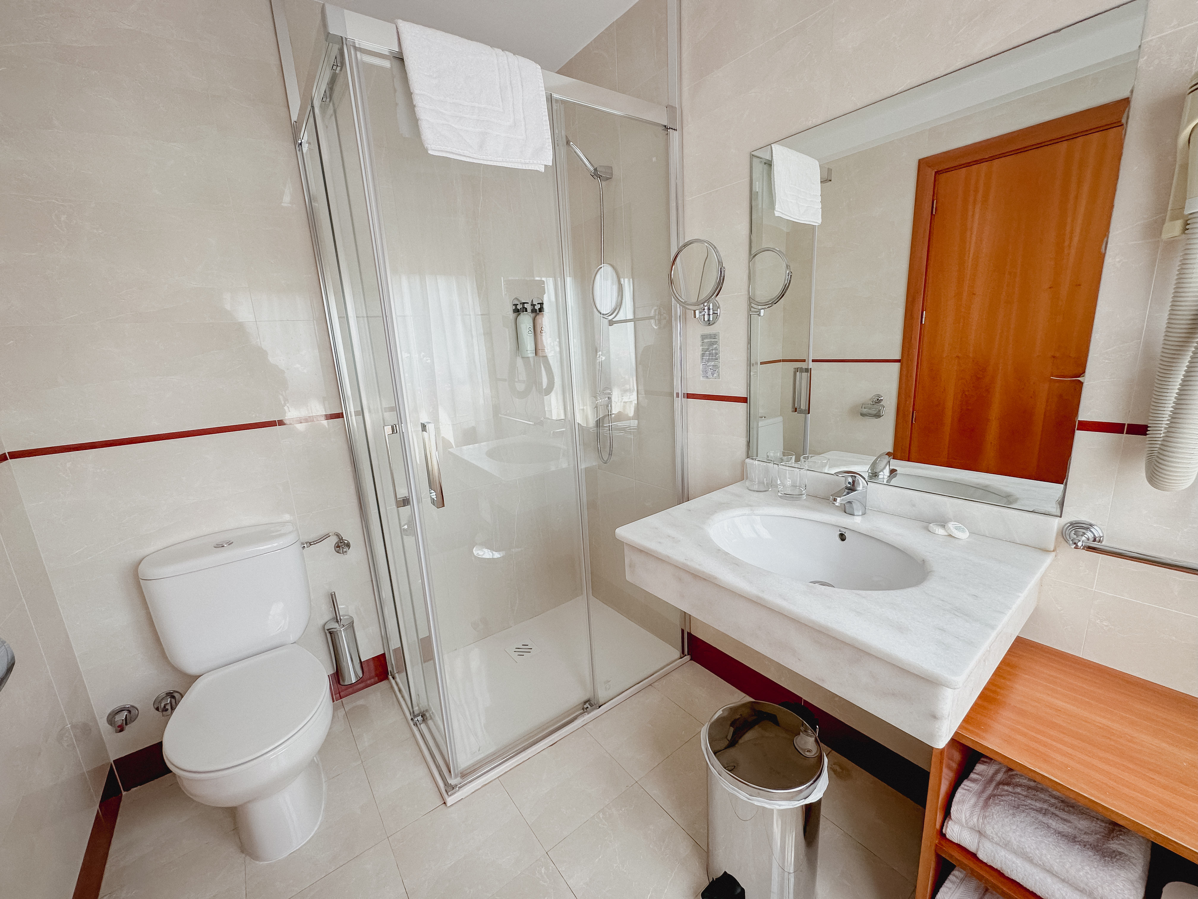 classy bathroom with marble tiles and round mirror