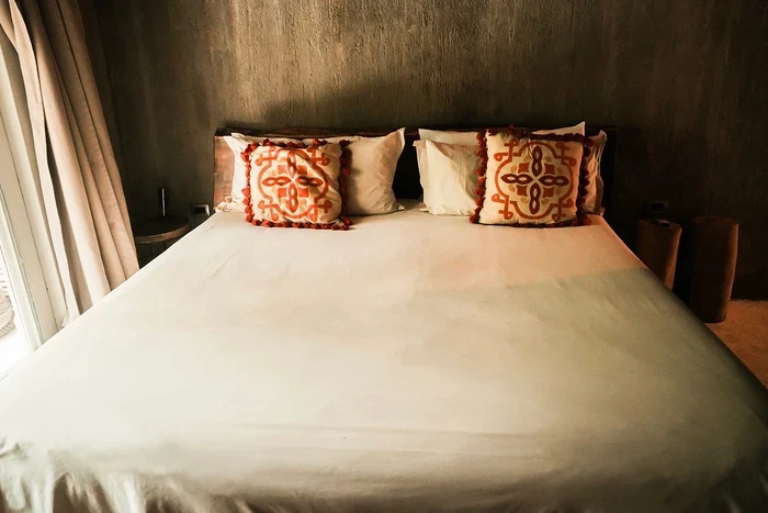 Standard Room at Nômade Tulum, highlighting bed with pillows.
