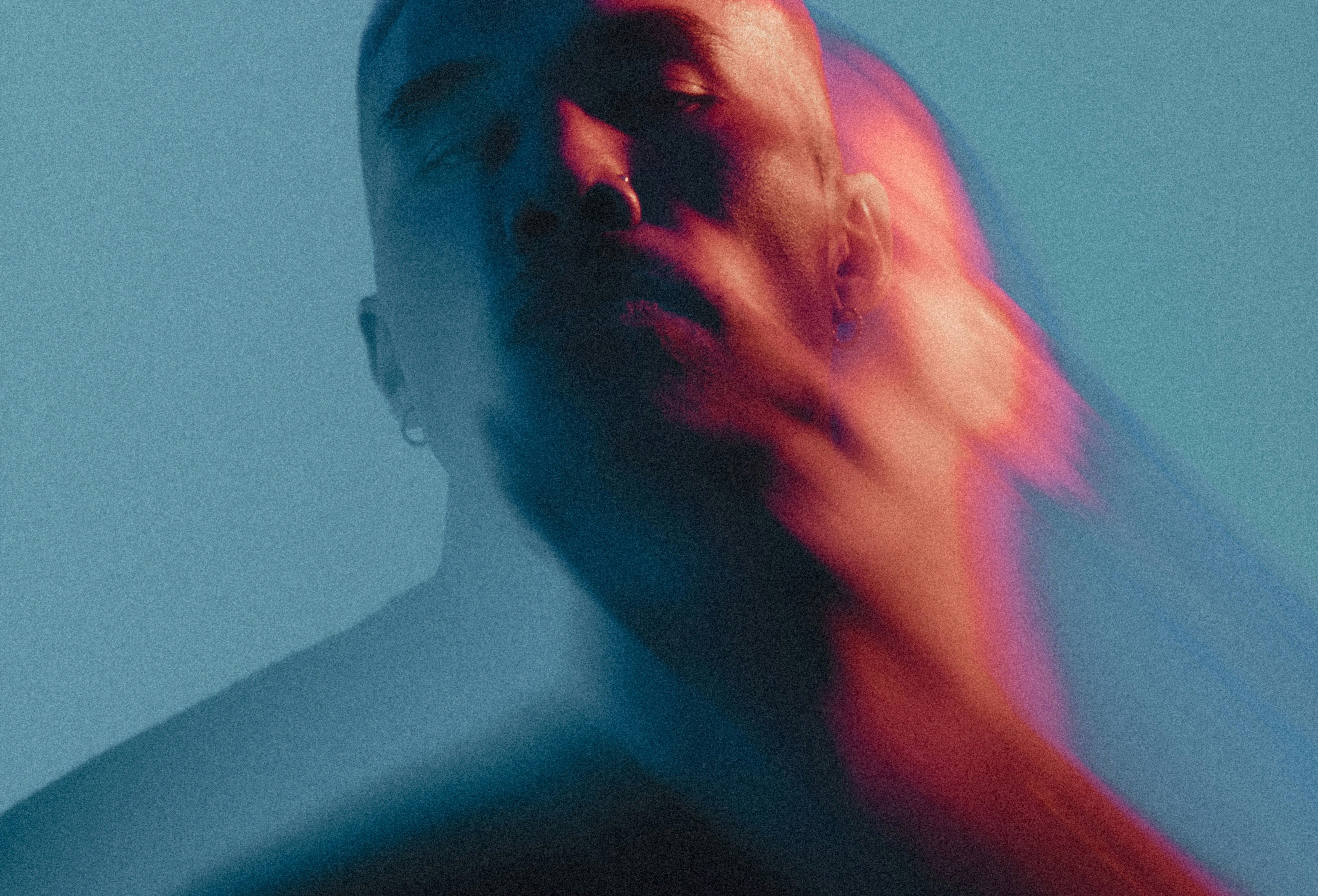 Man with blurred face in red and blue light