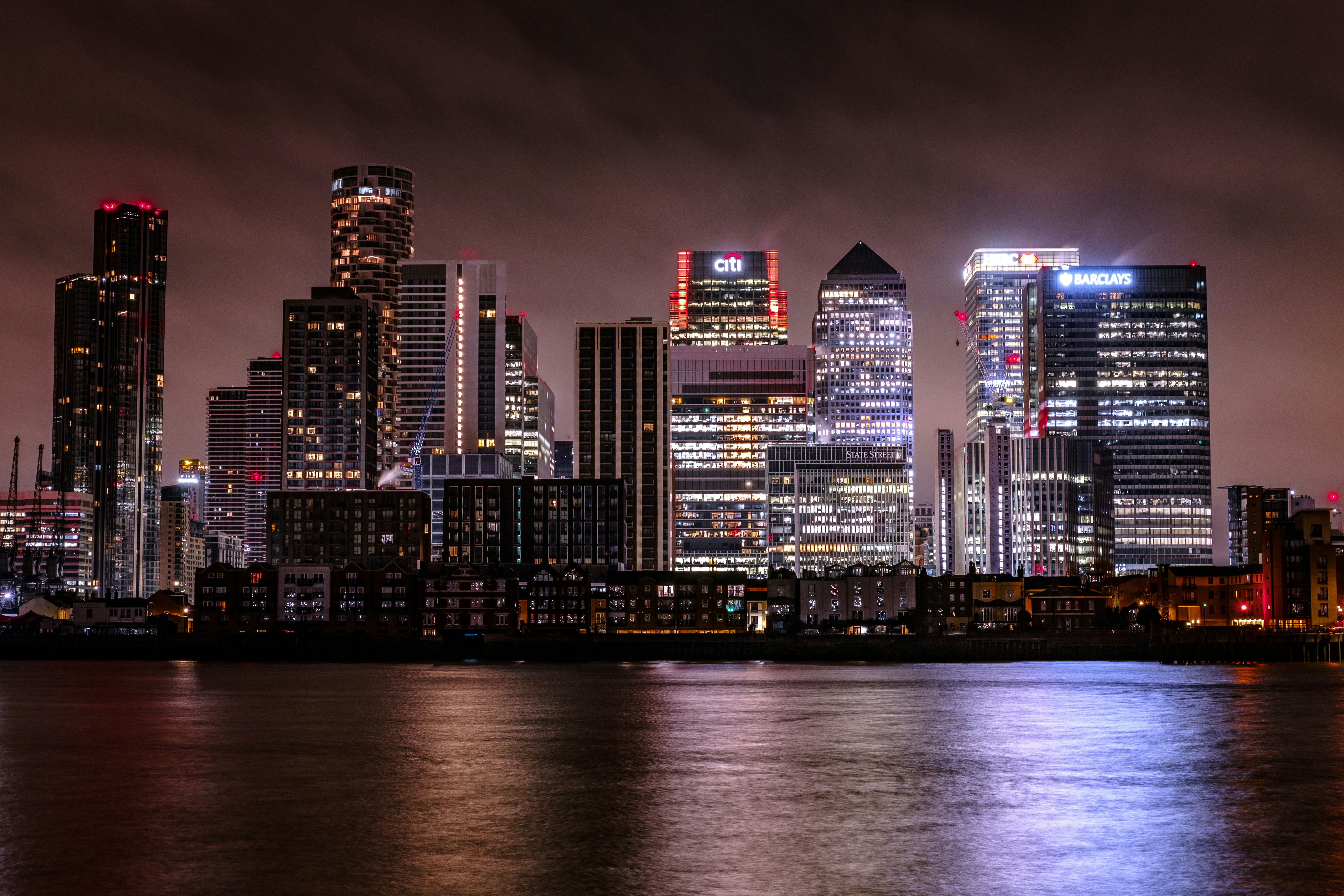 a city skyline at night with lights reflecting off the water