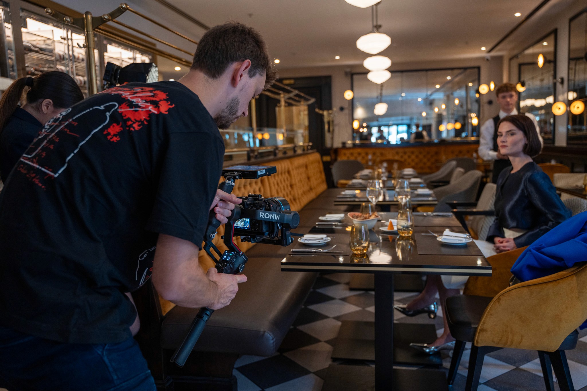 Videographer filming a model in a luxiurious restaurant